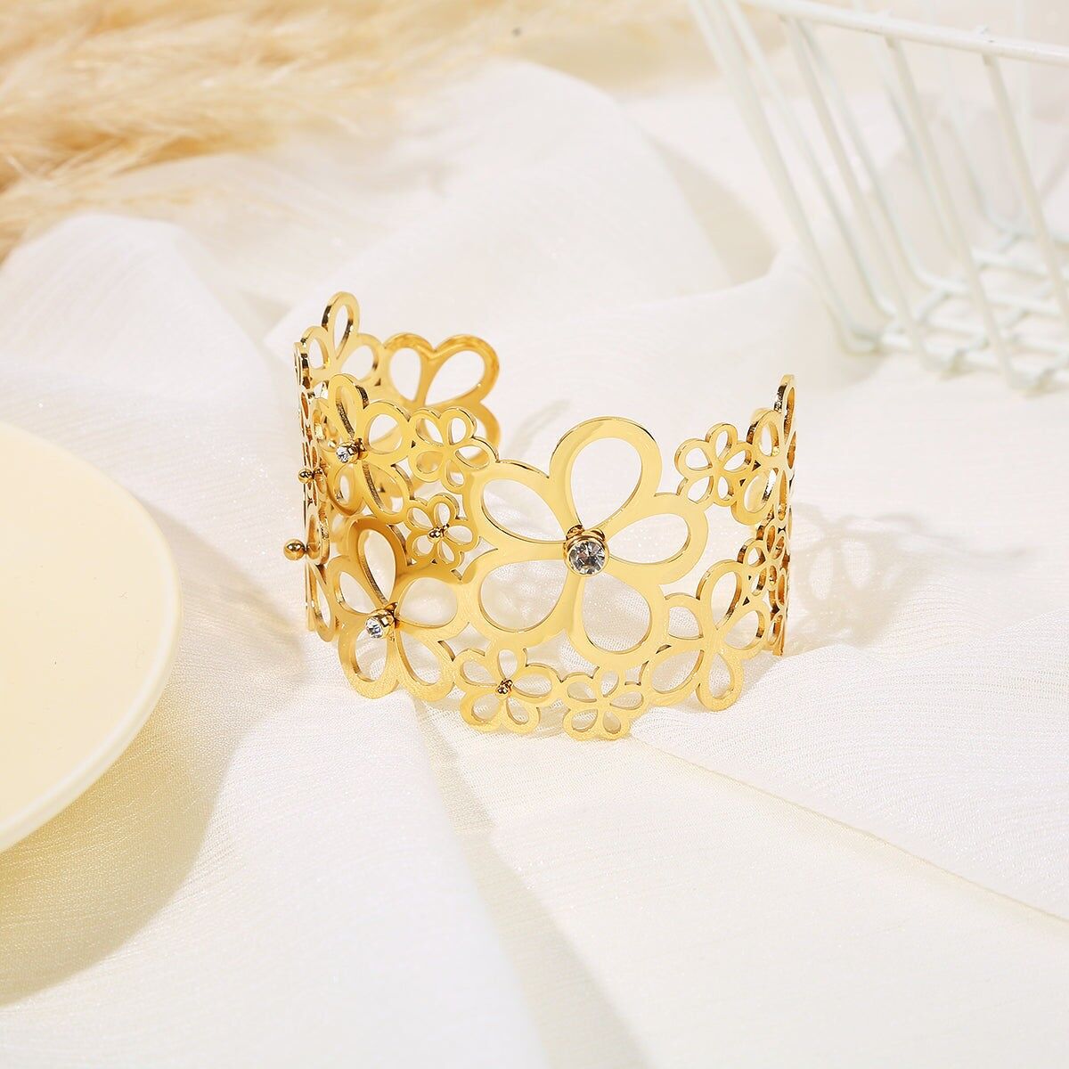 Verstellbares goldenes Armreif-Armband, verziert mit durchbrochenen Blumen in verschiedenen Größen mit Strasssteinen