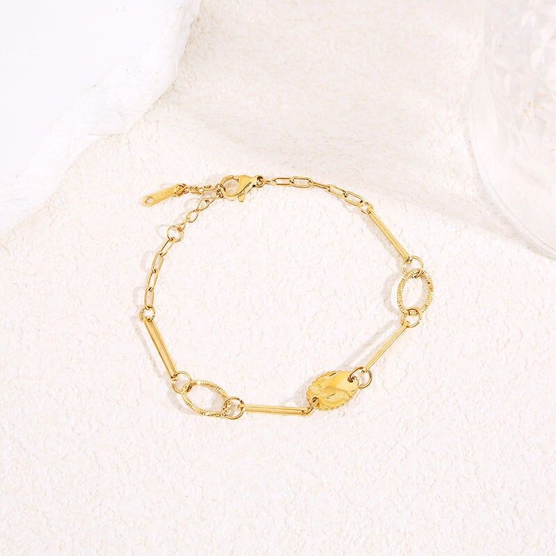 Goldkettenarmband mit langen, strukturierten ovalen Gliedern und graviertem Blattmedaillon