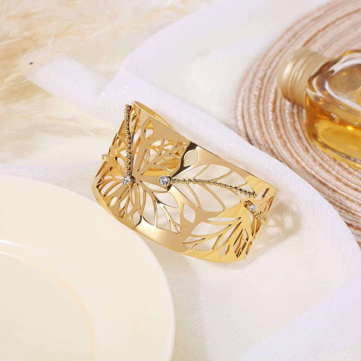 Verstellbares goldenes Armreif-Armband, verziert mit durchbrochenen Blättern und Strass-Linien