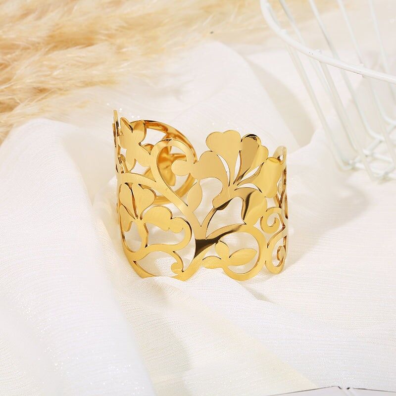 Durchbrochenes goldenes Armreif mit großem Blatt und stilisiertem Blütenblattmotiv