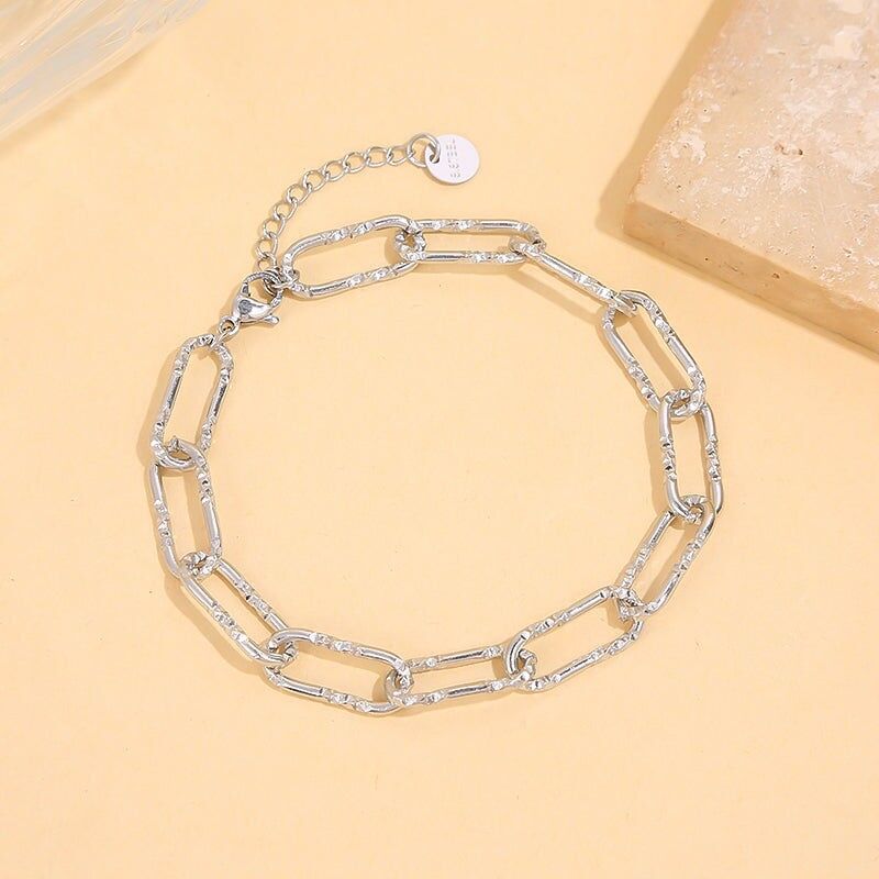 Silbernes Kettenarmband mit länglichen strukturierten Gliedern und Glitzereffekt