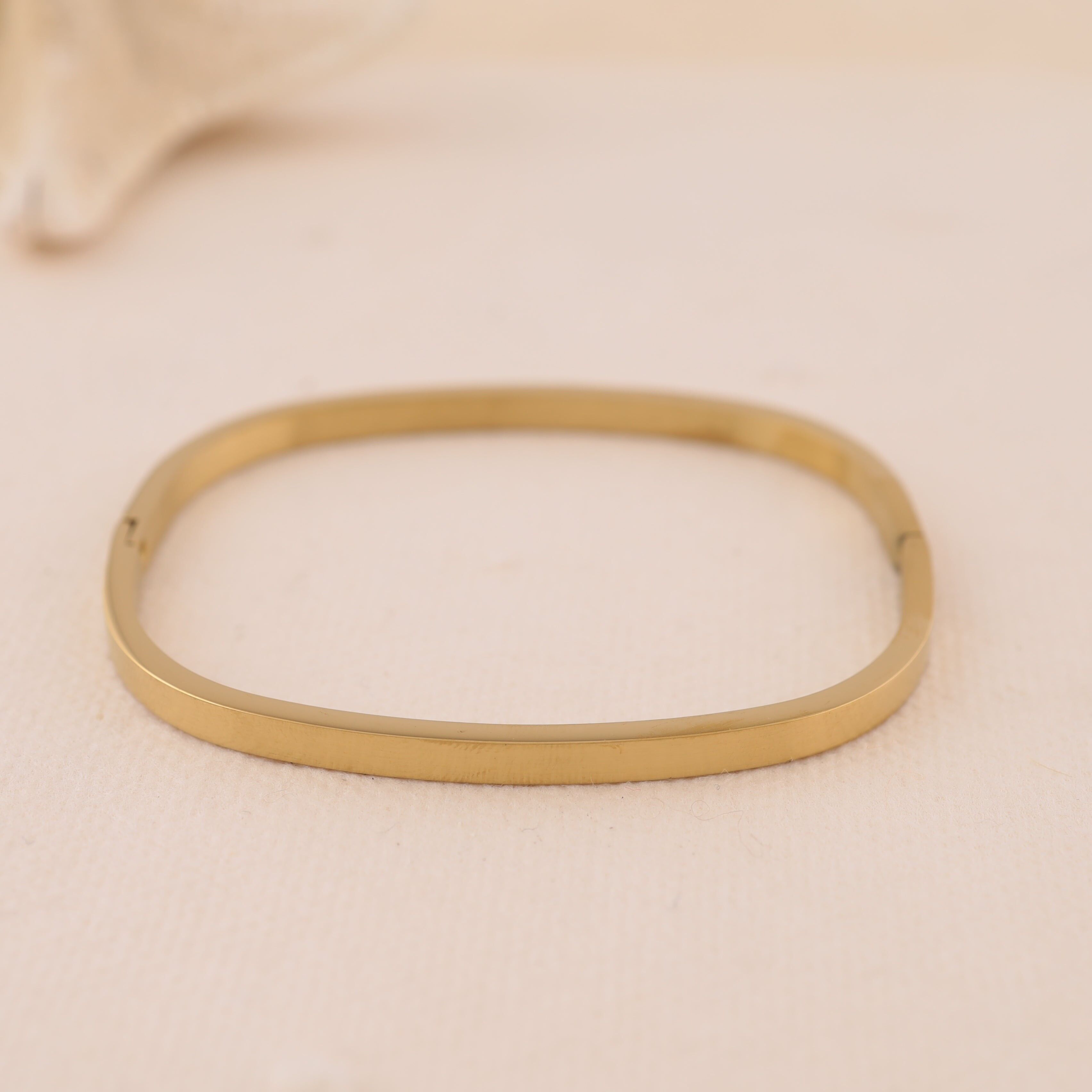 Dünner rechteckiger, abgerundeter Armreif aus Gold mit quadratischem Rand und dezentem Verschluss