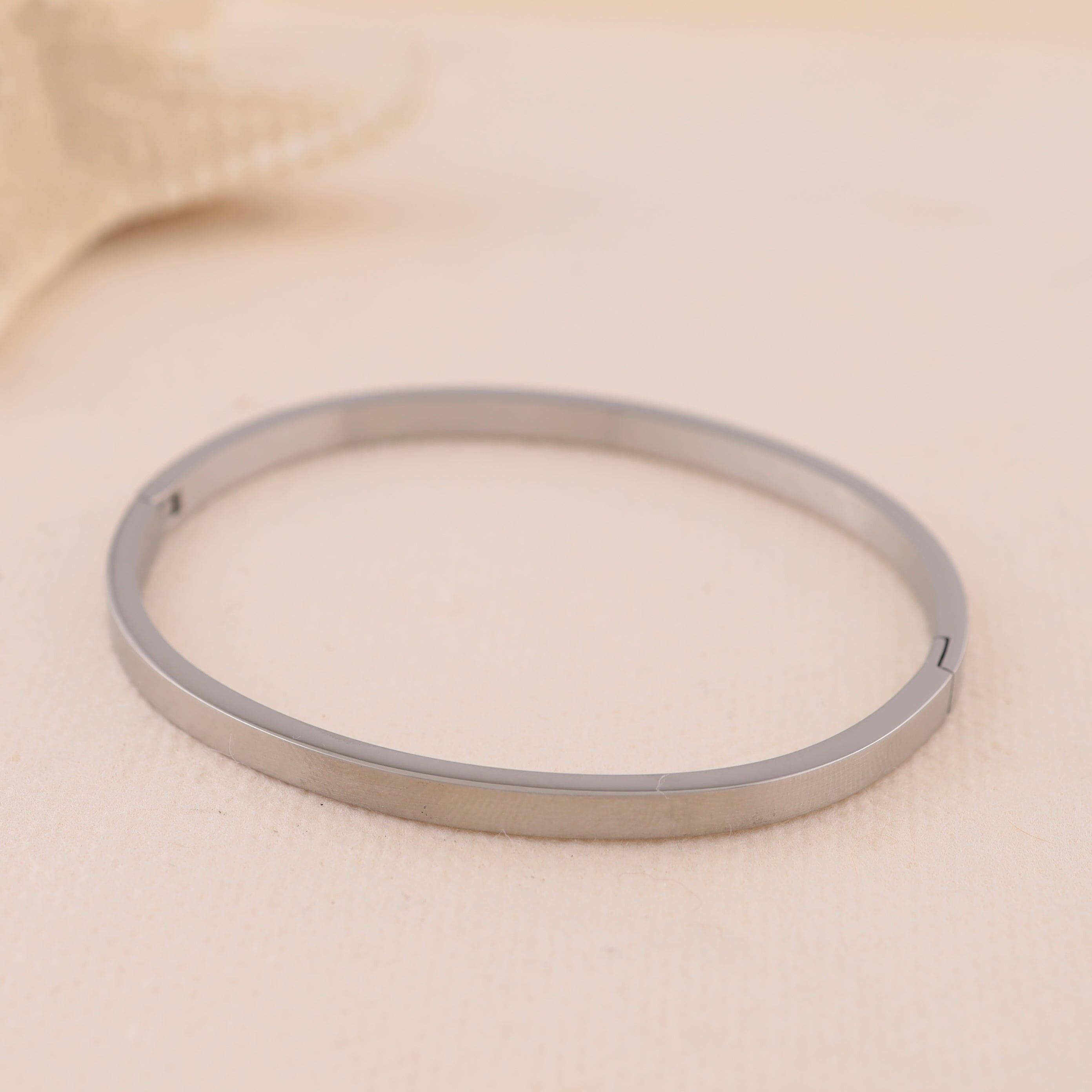 Bracciale rigido ovale in argento con bordo quadrato e chiusura discreta