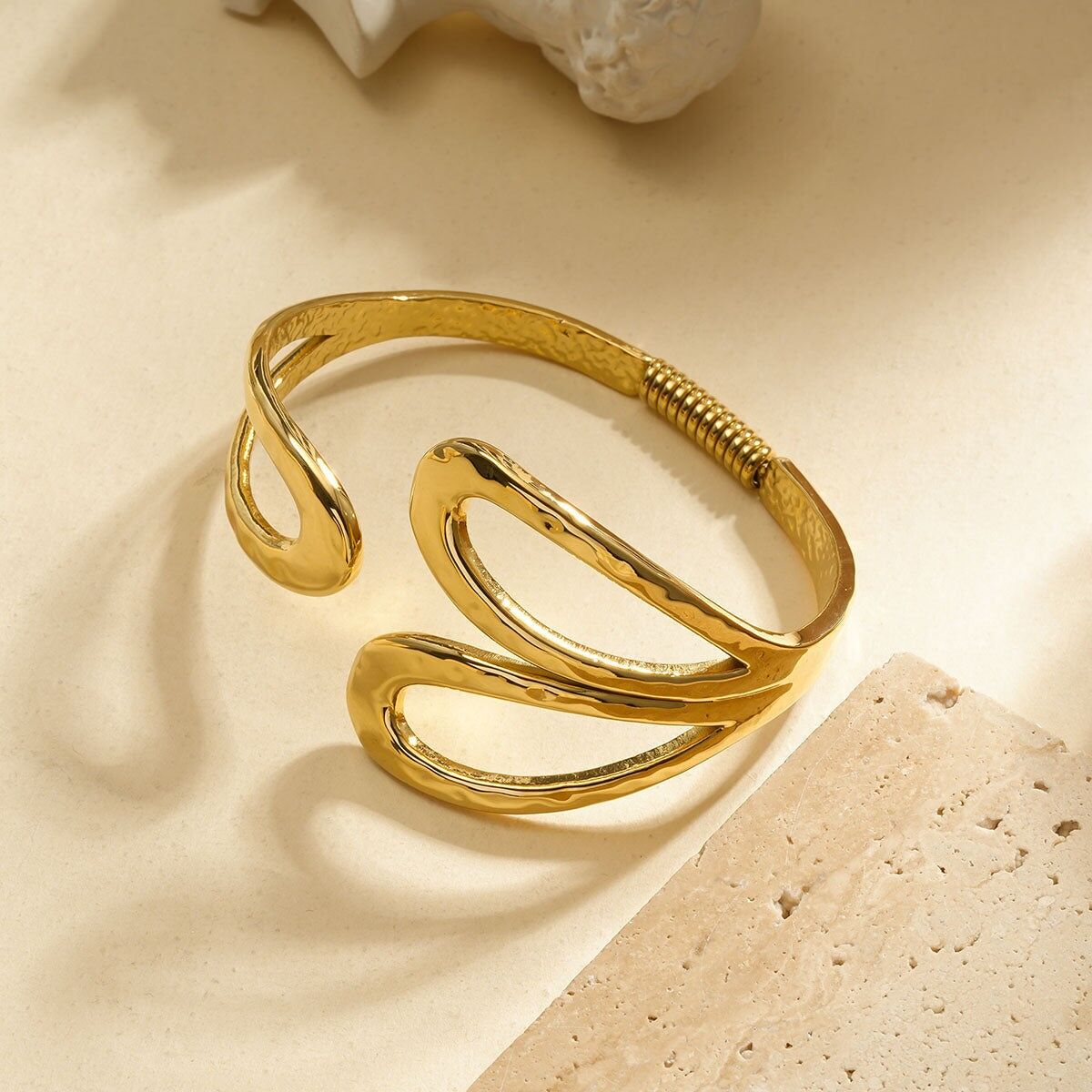 Bracciale bangle aperto in oro con motivi traforati a forma di gocce martellate