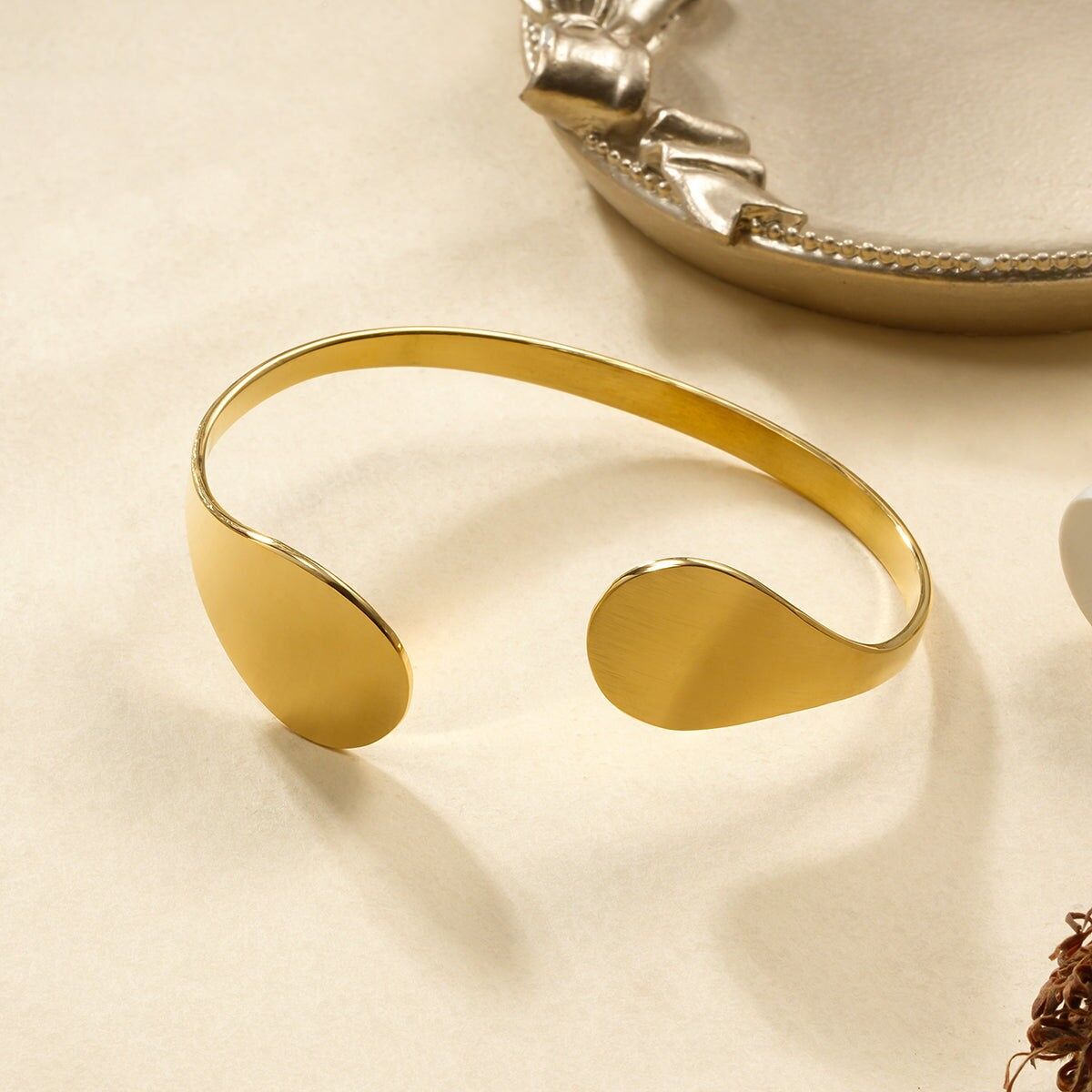 Bracciale rigido in oro con estremità pendenti