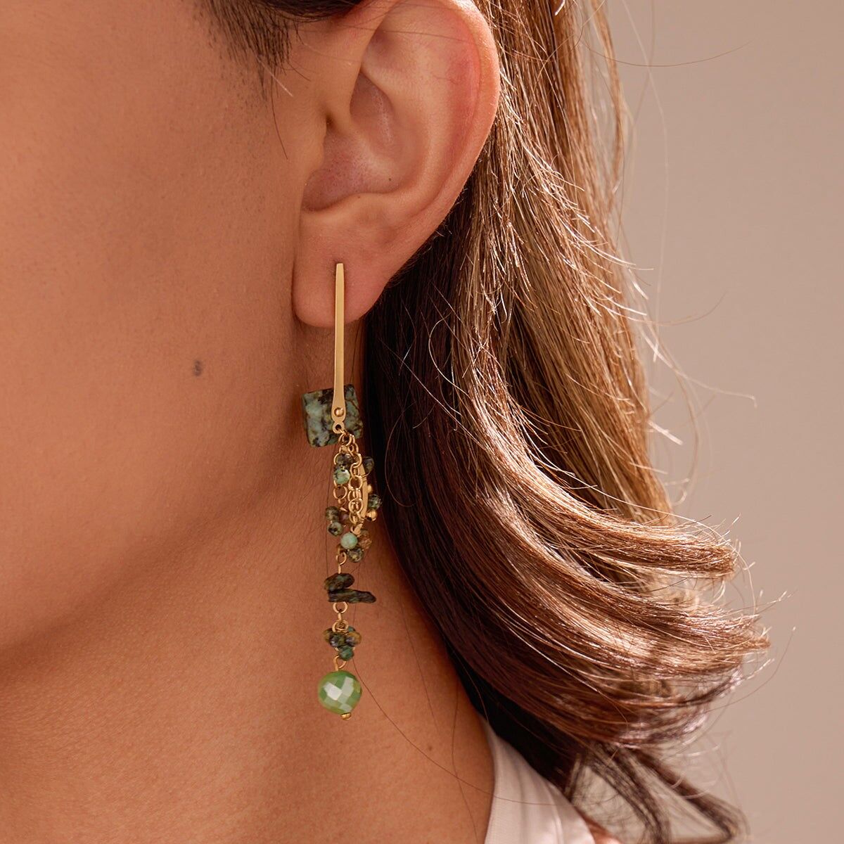 Orecchini pendenti in oro con pietre verdi e dettagli geometrici