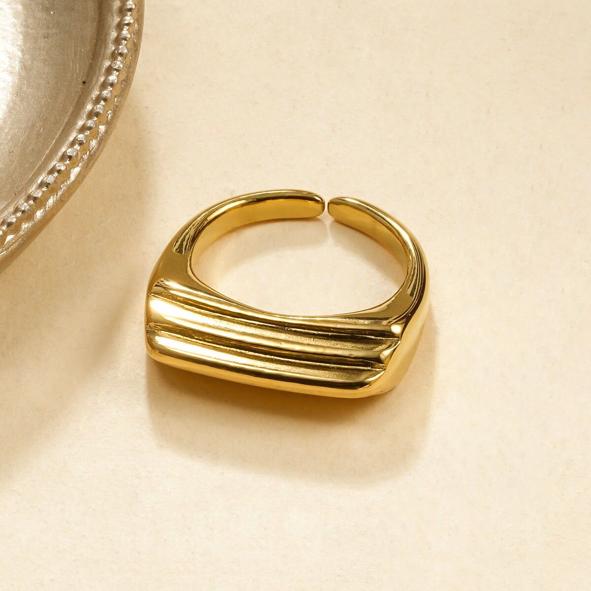 Anello rettangolare in oro con rilievi lineari