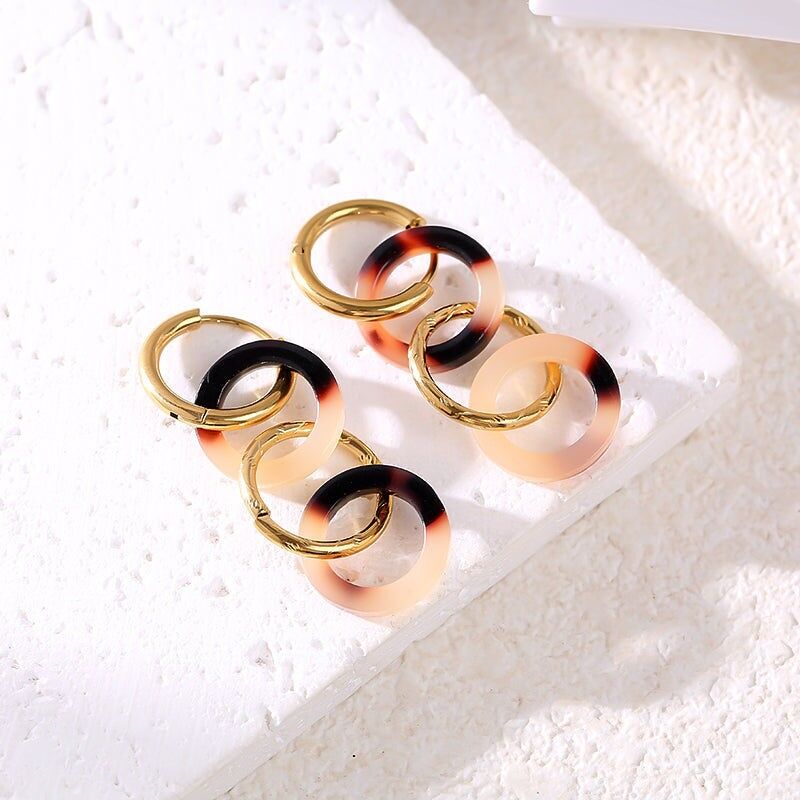 Orecchini a cerchio in oro che alternano cerchi dorati e motivi animali