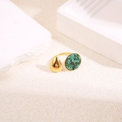 Anillo de oro con efecto espejo en forma de gota y círculo de piedra verde.