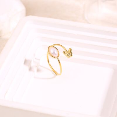 Anillo de oro ajustable con frente cruzado con perla ovalada y extremo de mariposa
