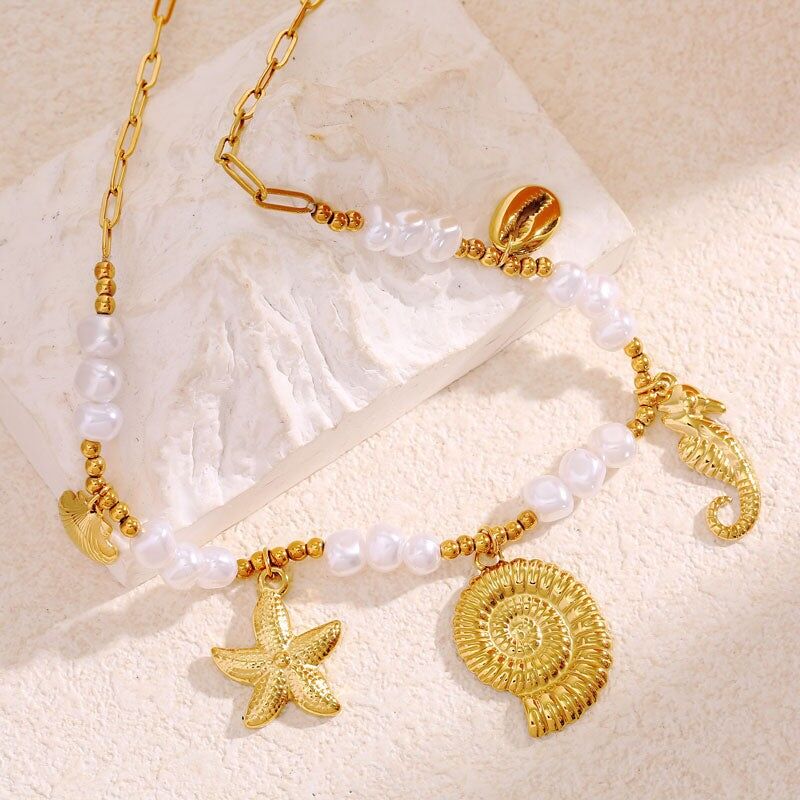 Collana con catena e perline con pendenti a forma di stella marina, conchiglia e cavalluccio marino