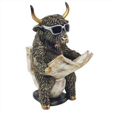 Figurine de vache des Highlands sur les toilettes lisant un journal