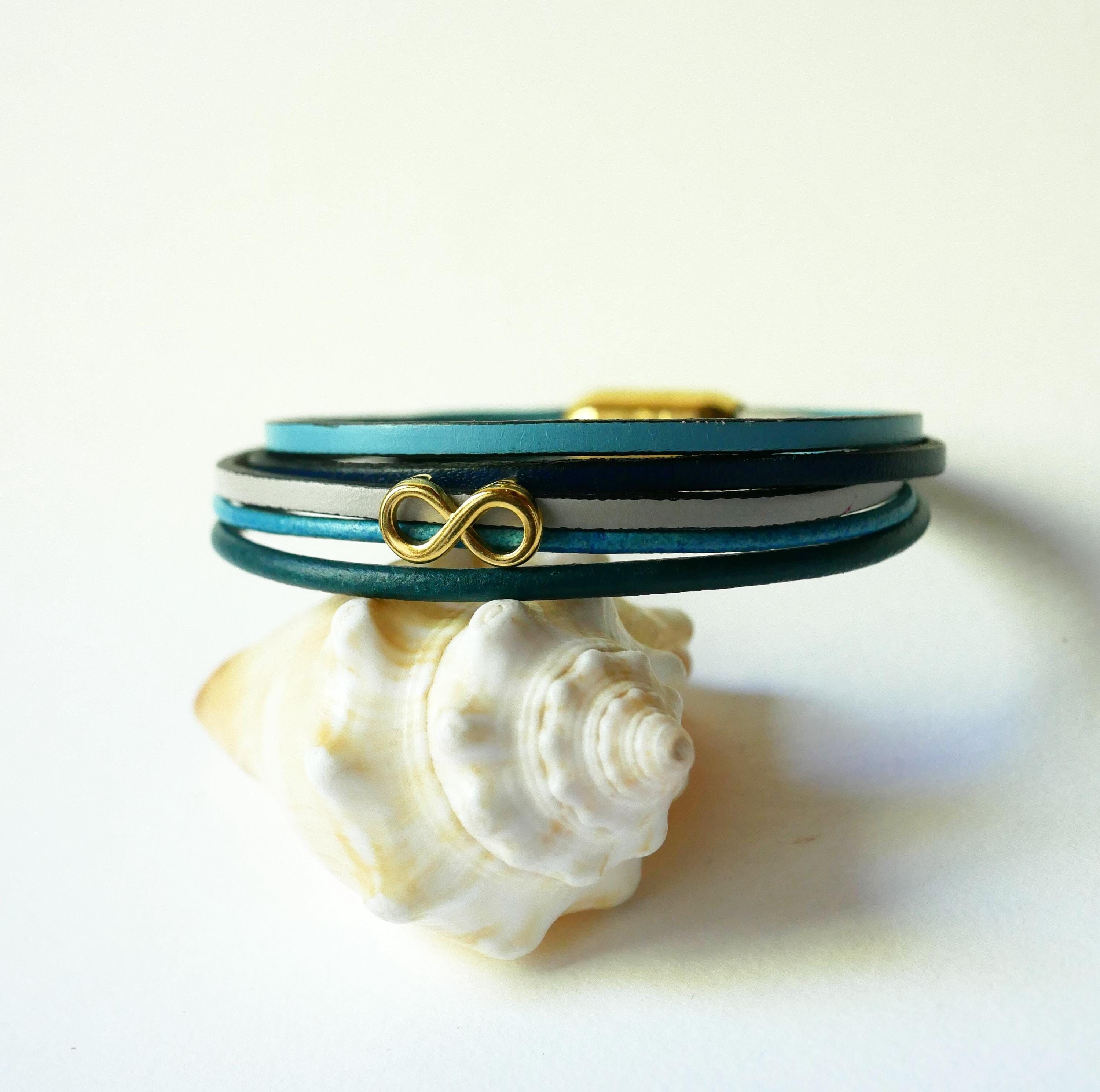Bracelet multi-liens de cuir tons bleu, turquoise, marine et doré, avec un symbole infini doré et fermoir aimanté élégant