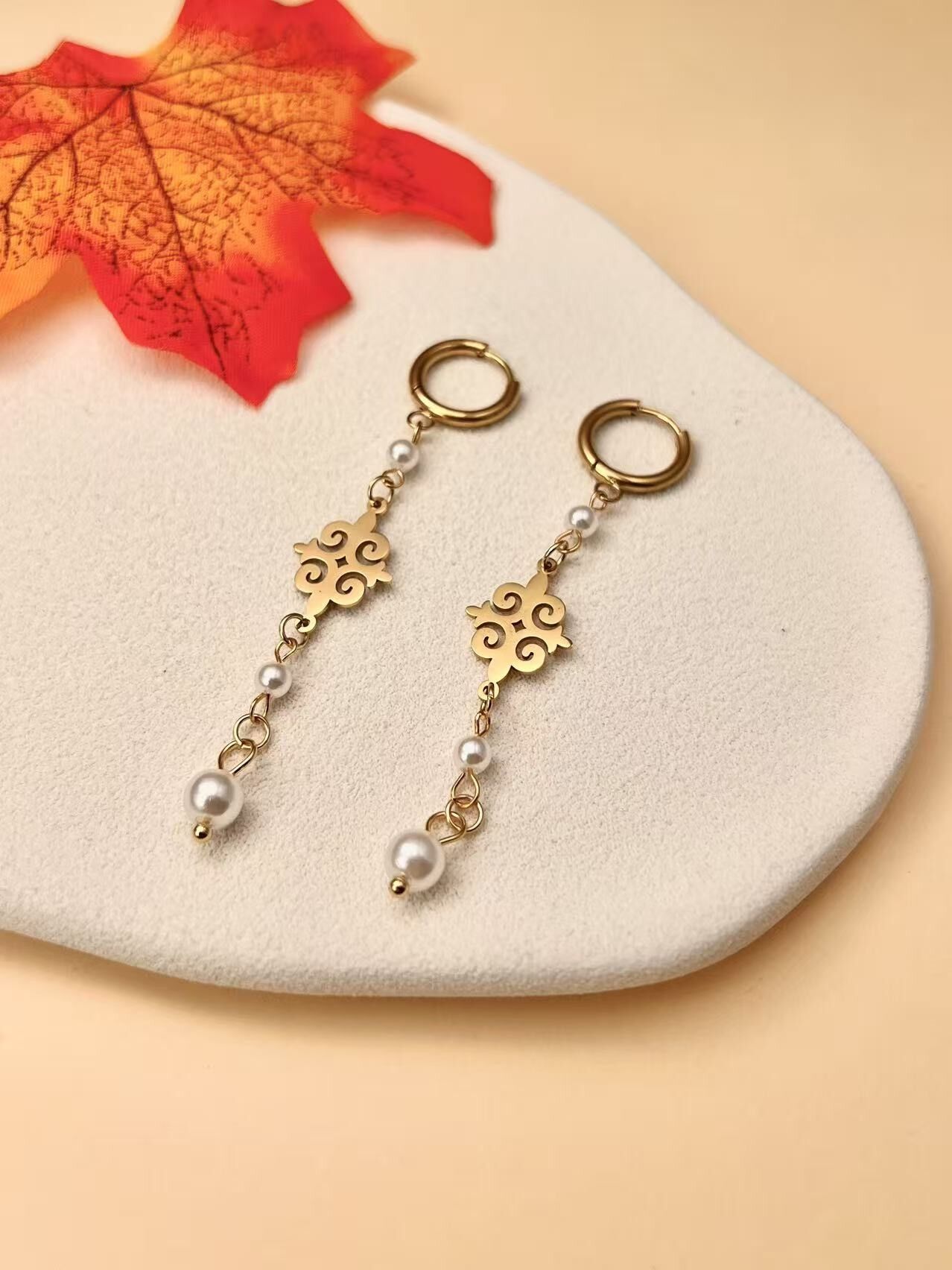 Goldene Ohrhänger mit Perlen und Barockmotiv