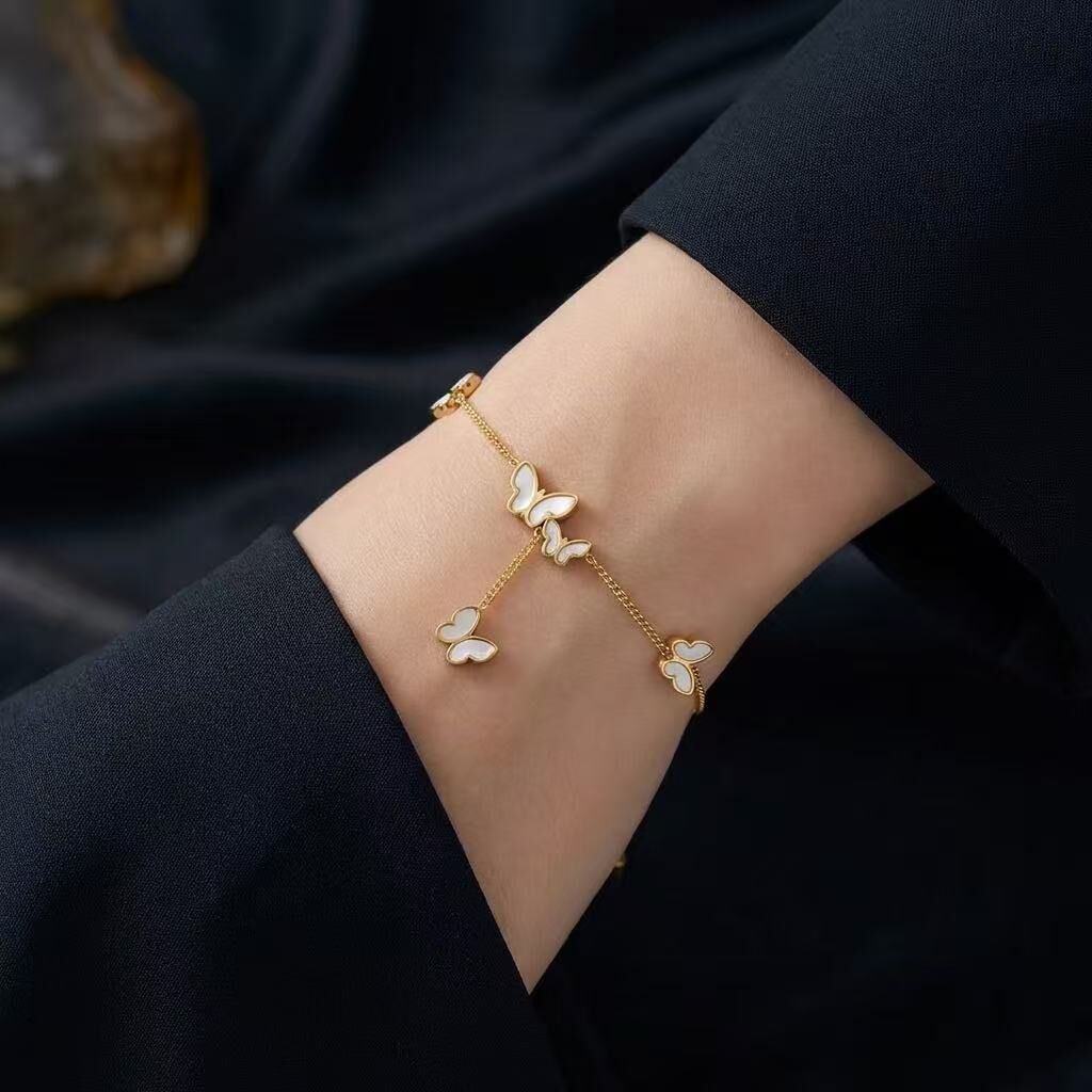 Pulsera de acero inoxidable dorado con mariposas de perlas colgantes