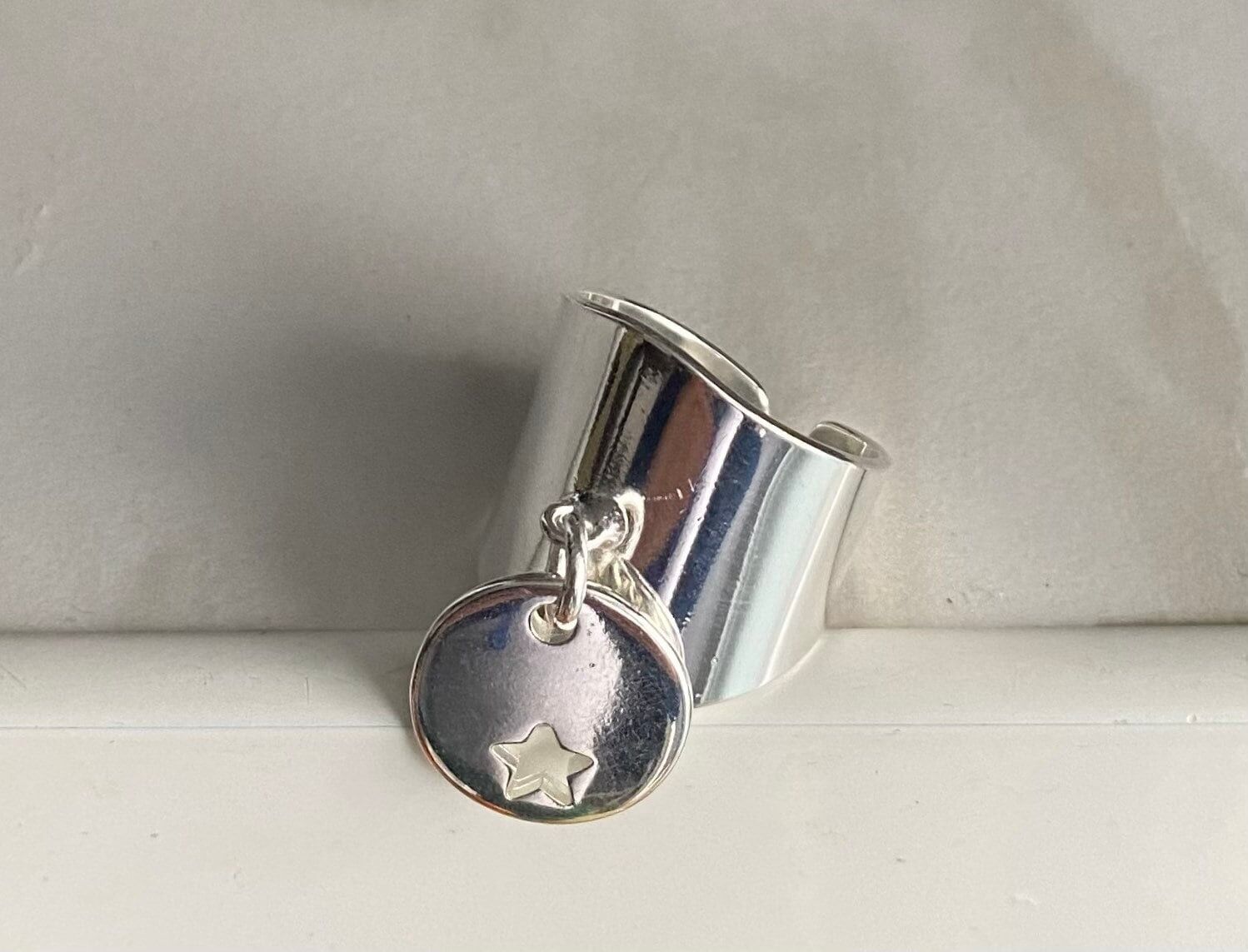 Anello grande con piccolo ciondolo a forma di stella