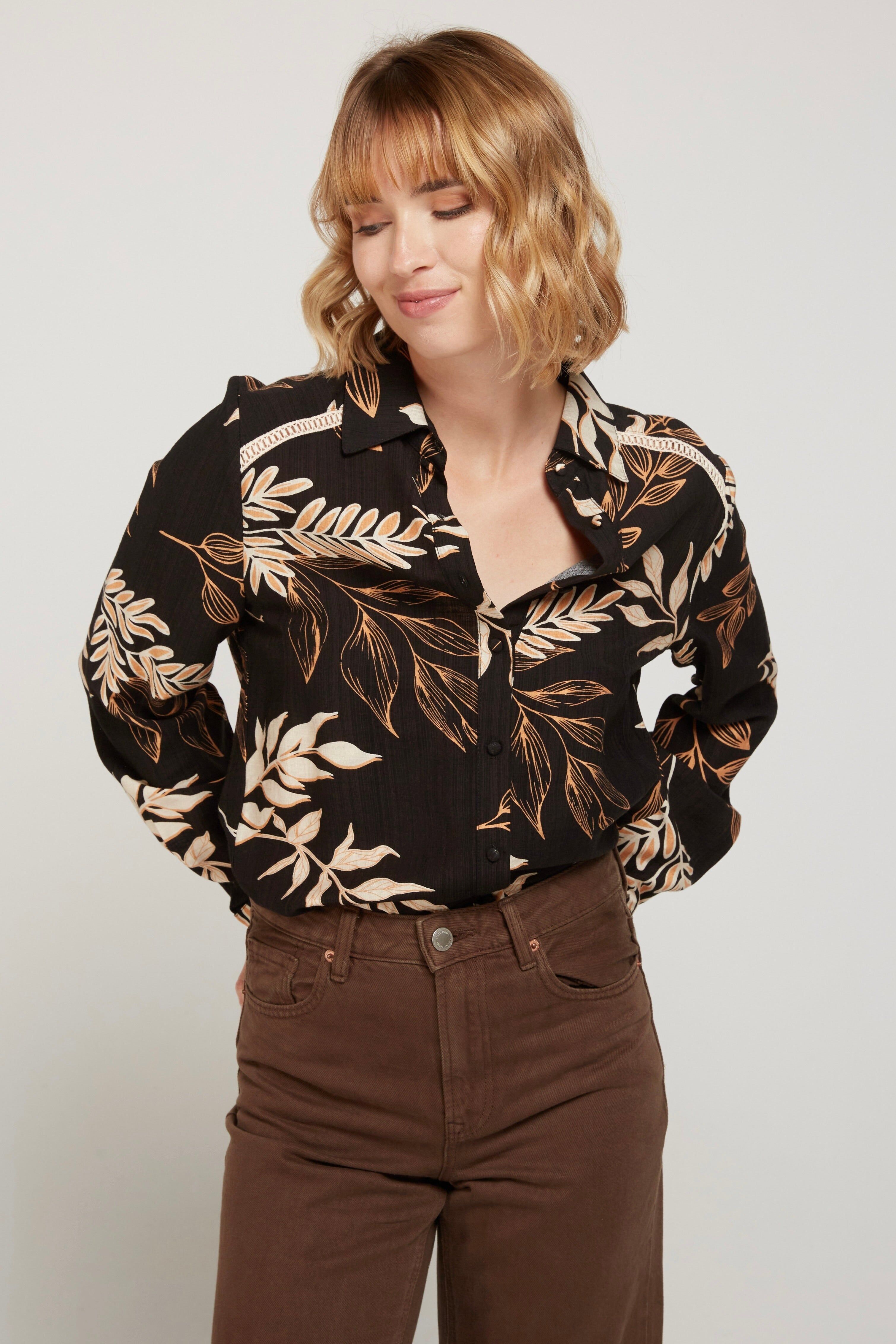 DIMA - Camisa negra con estampado de hojas, ribete de encaje de escalera en hombros, tapeta y mangas. Tejido 65% algodón, 35% viscosa. Combina con el vestido SHANA.