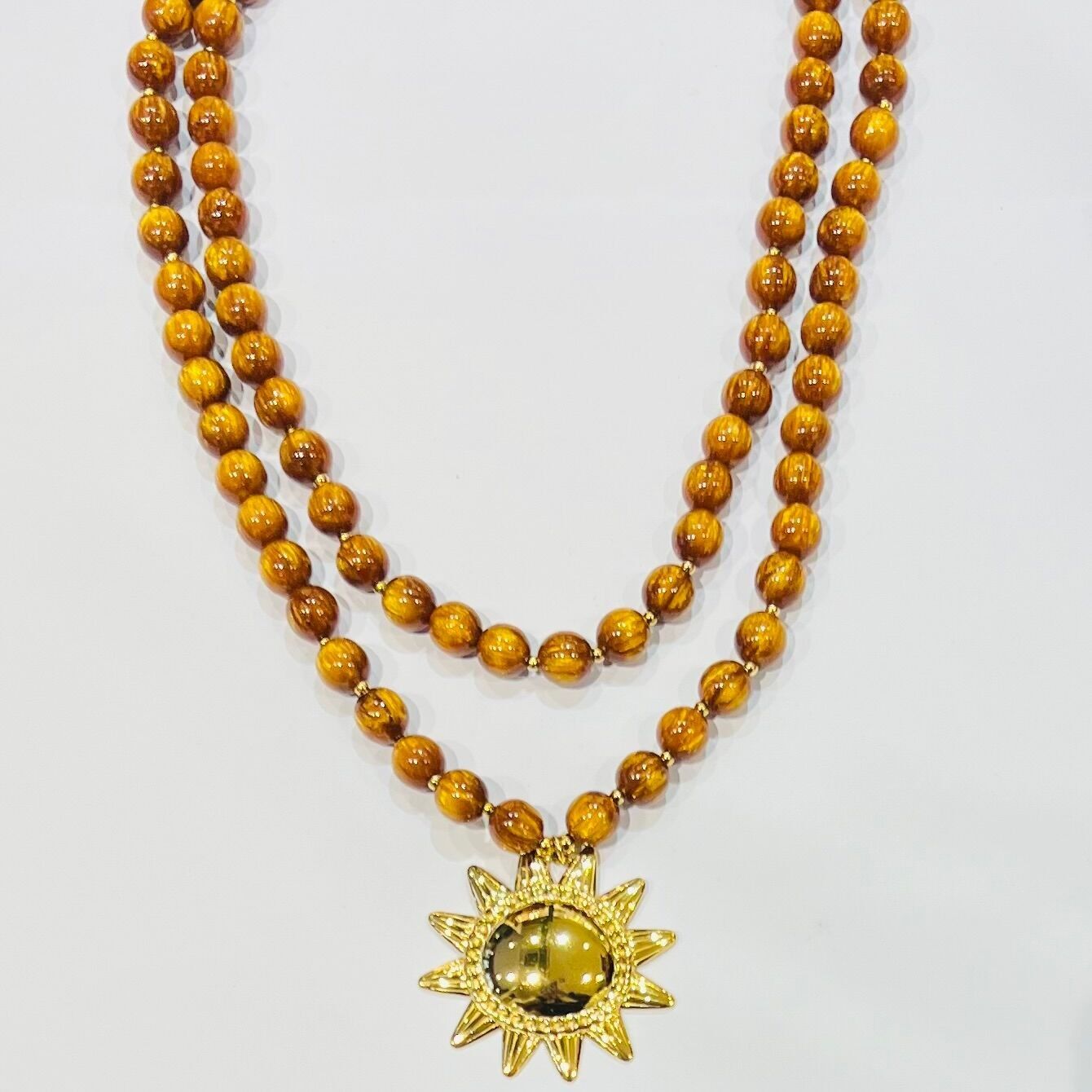 Collana in acciaio con due perle occhio di gatto e ciondolo sole