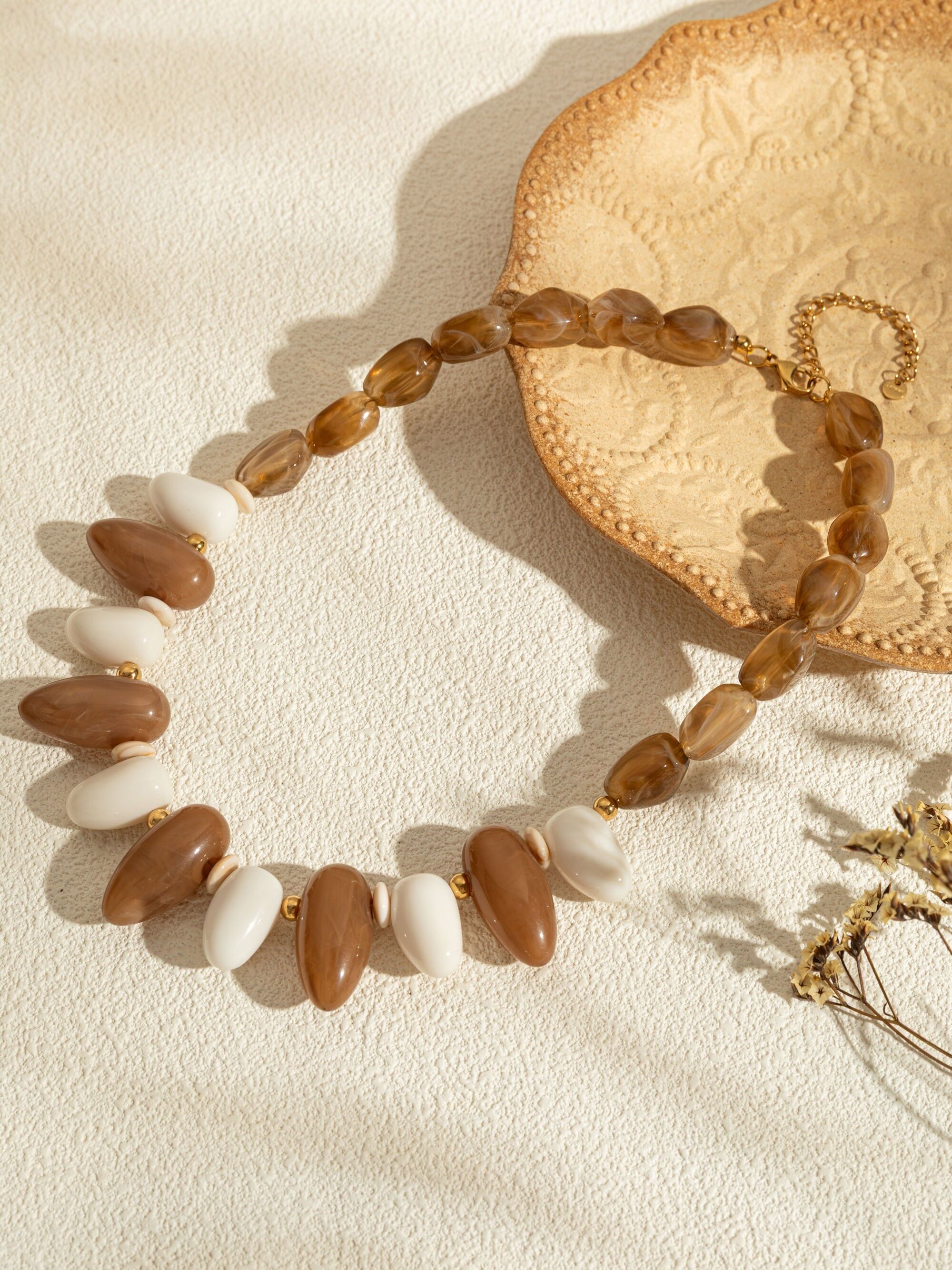 Collares ovalados en resina coloreada y elegante cadena dorada.