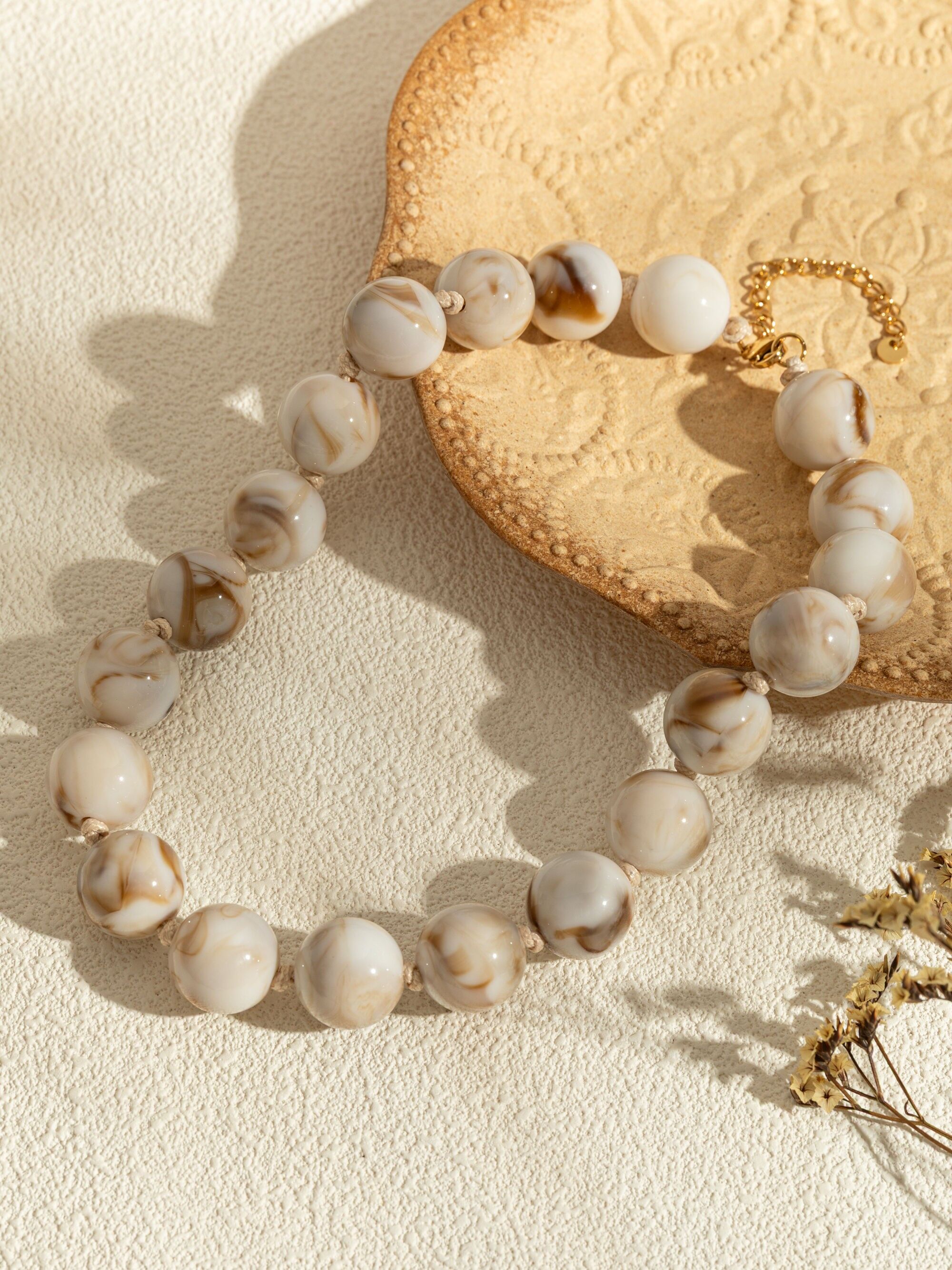 Collares de perlas redondas de resina de colores y elegante cadena dorada.