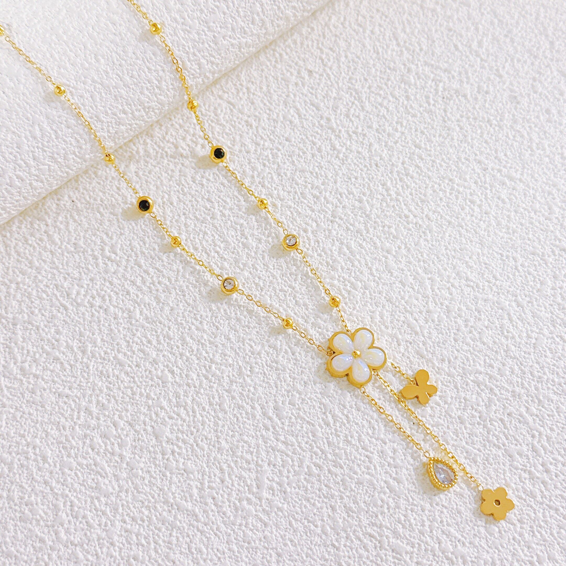 Perlenkette mit Blume und Schmetterling aus goldfarbenem Edelstahl