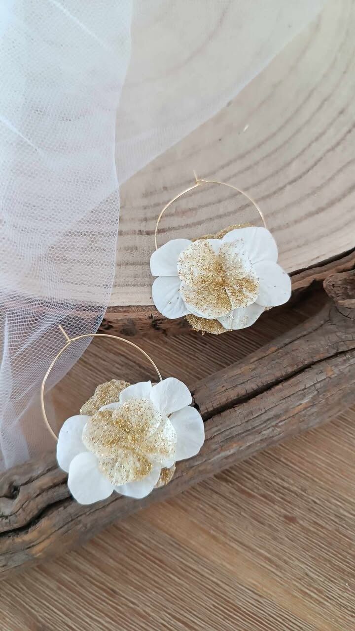 Pendientes de aro dorados brillantes decorados con flores secas
