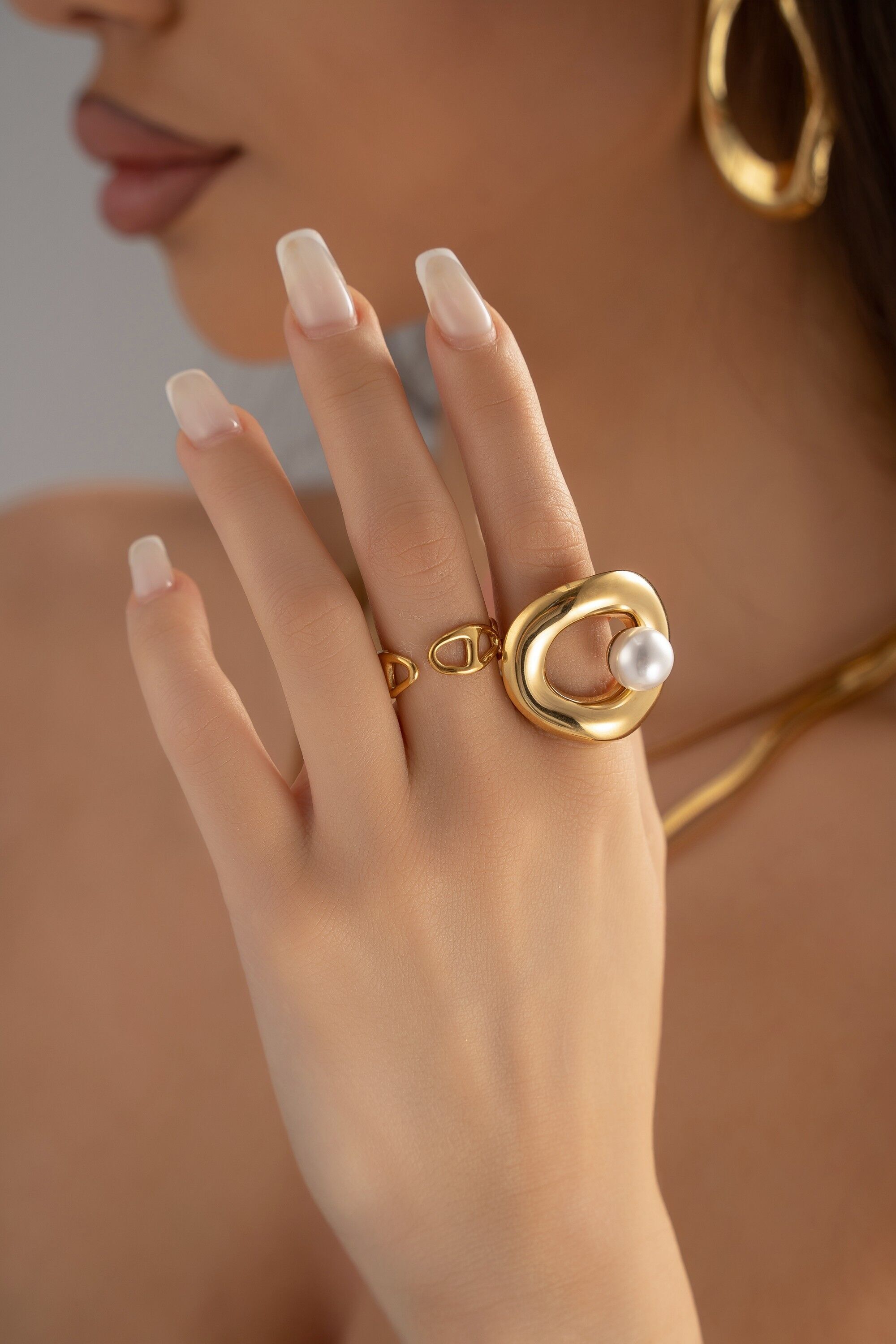 Geformter weißer Perlenring aus goldfarbenem Edelstahl