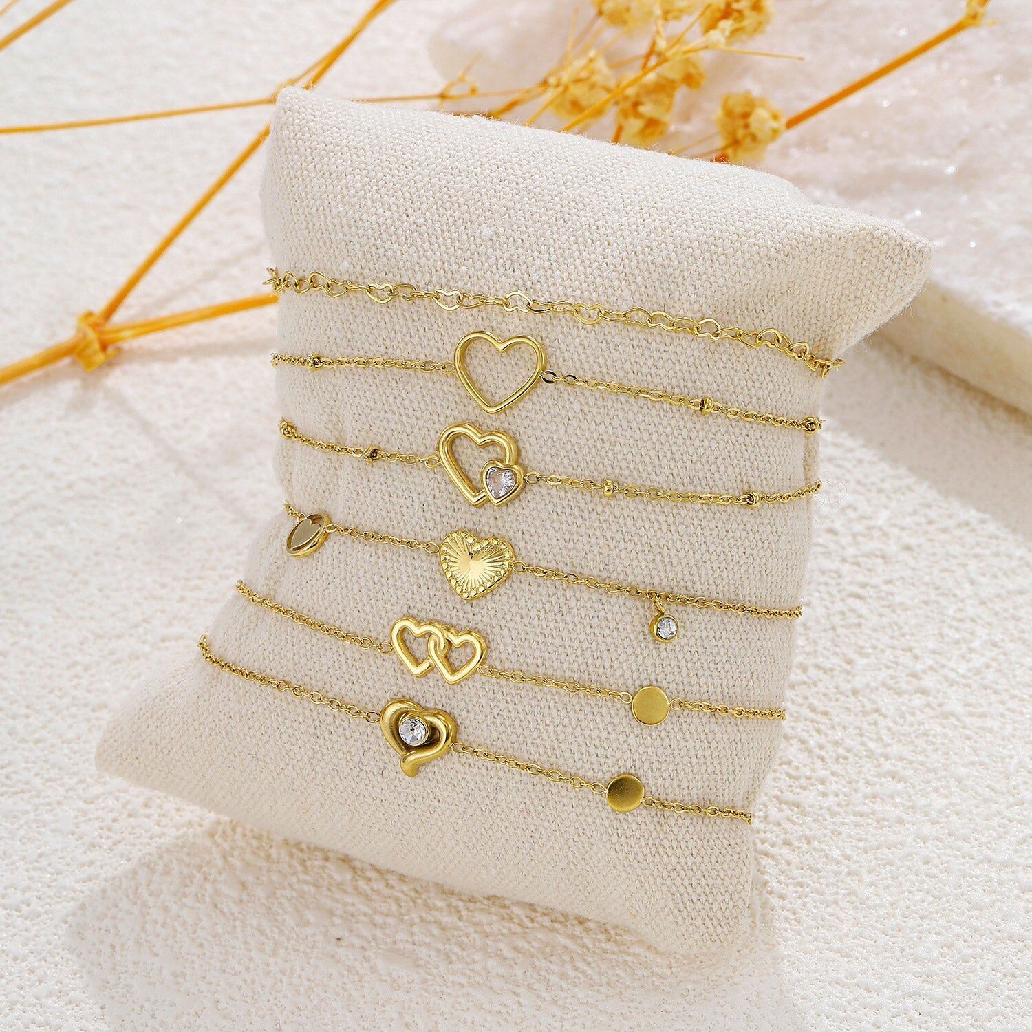 Set di 6 braccialetti dorati a tema cuore su cuscino