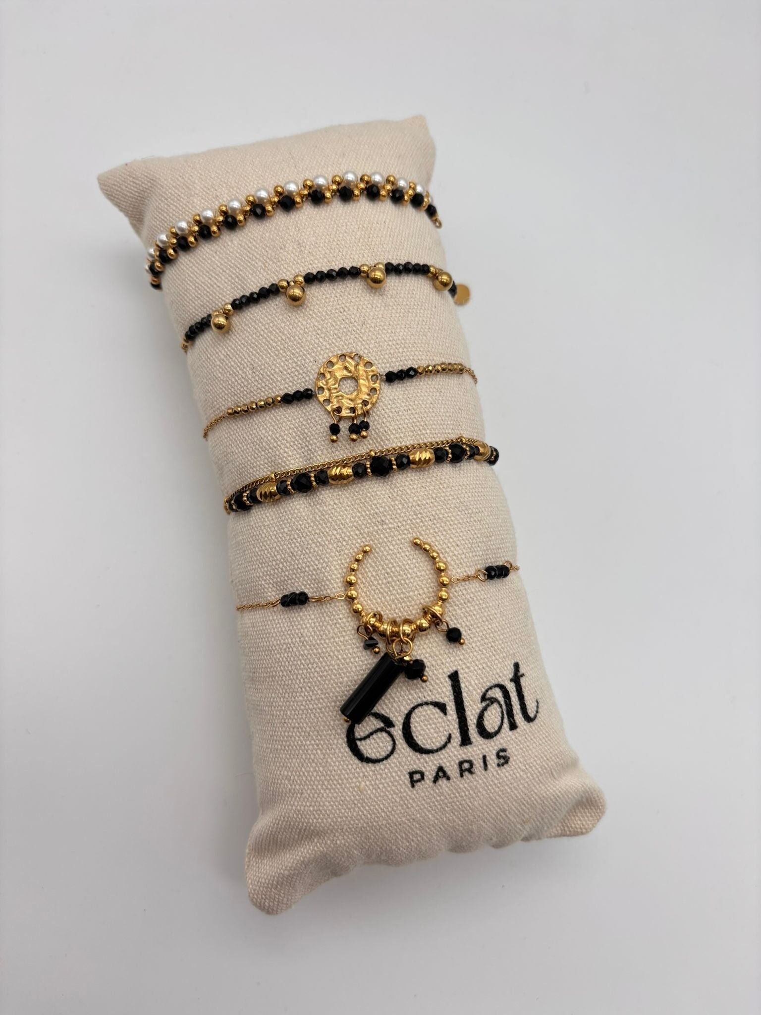 Set di bracciali con pietre nere e perle su un cuscino