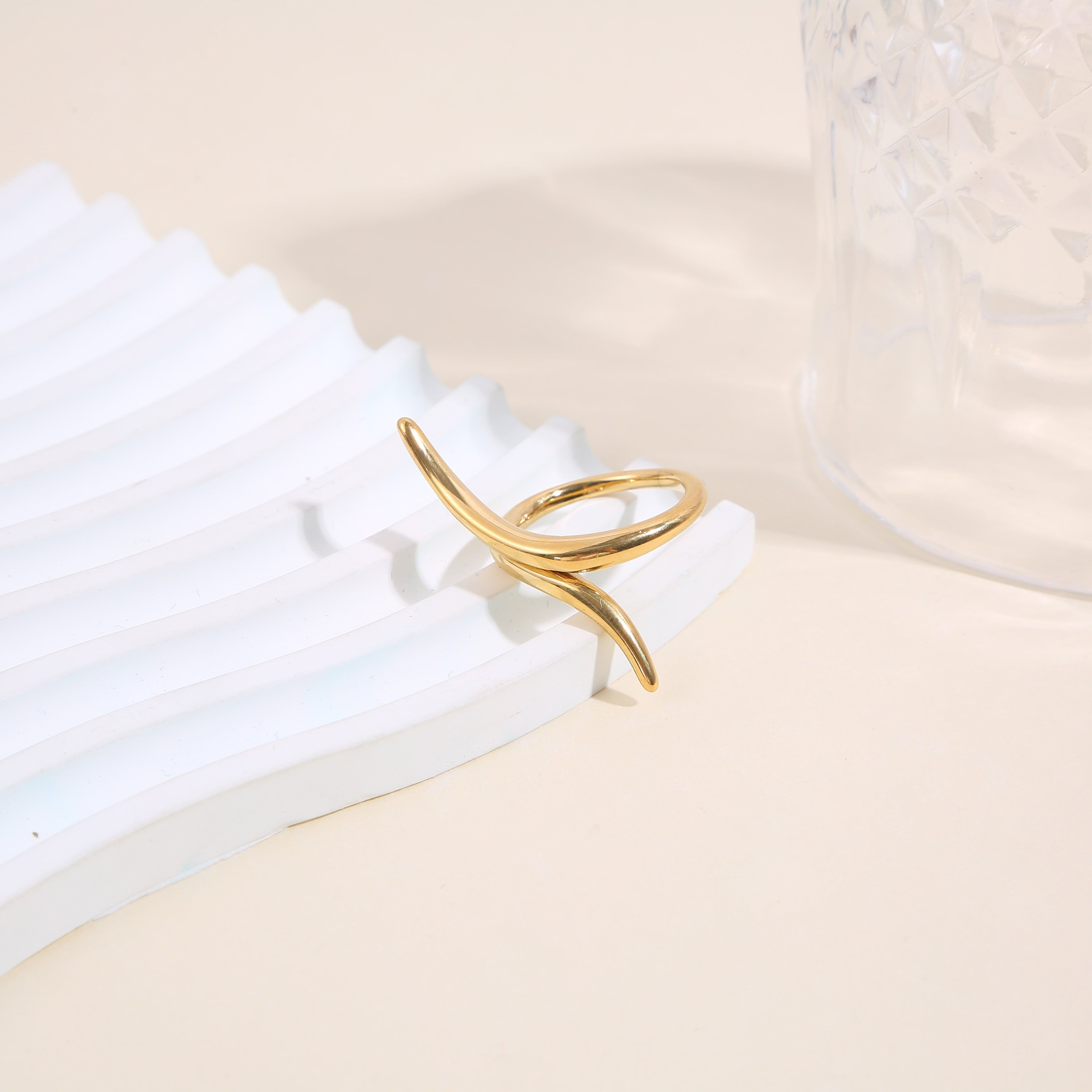 Anello in oro con design minimalista lungo e incrociato nella parte anteriore.