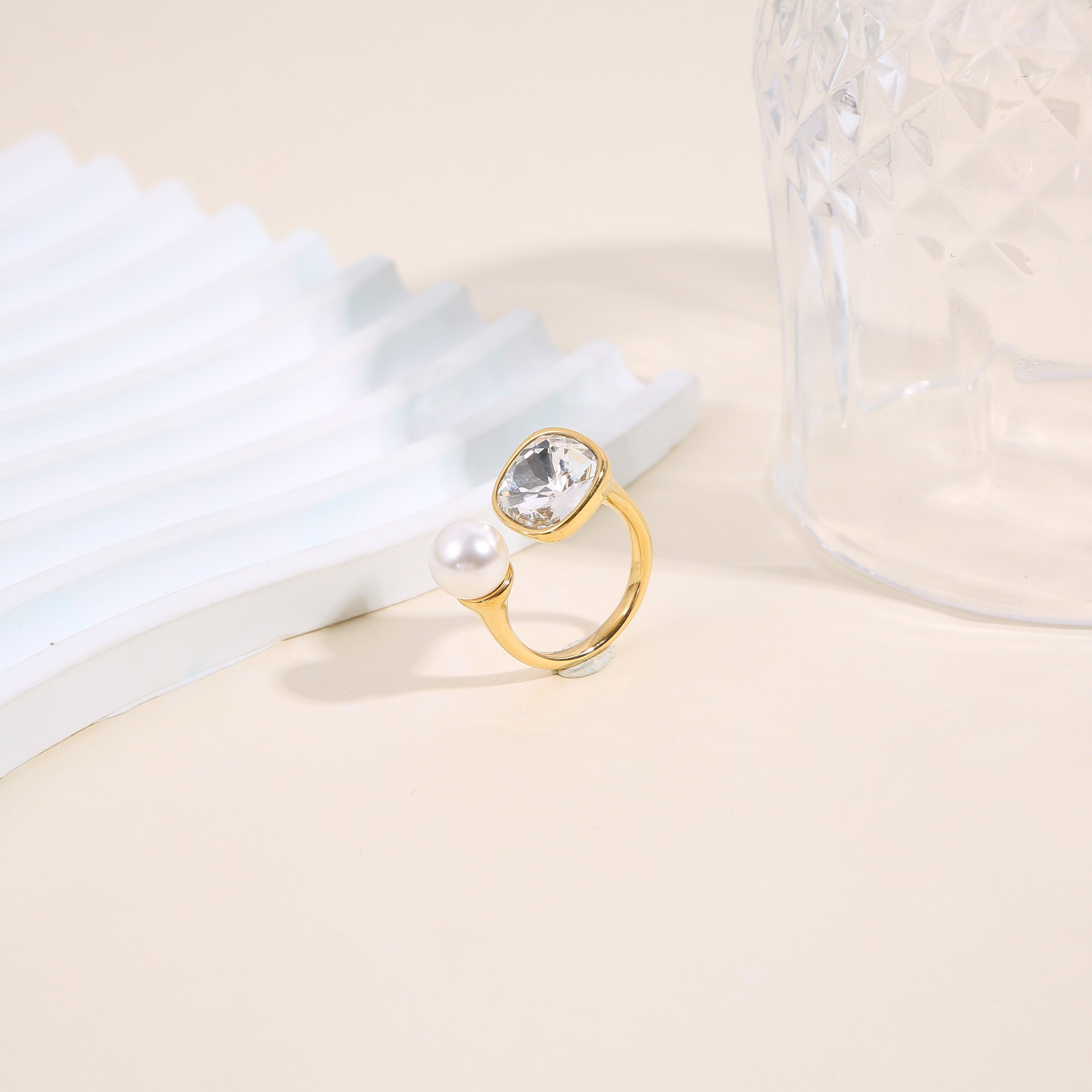 Anello in oro aperto sul davanti con strass quadrati e una perla bianca rotonda