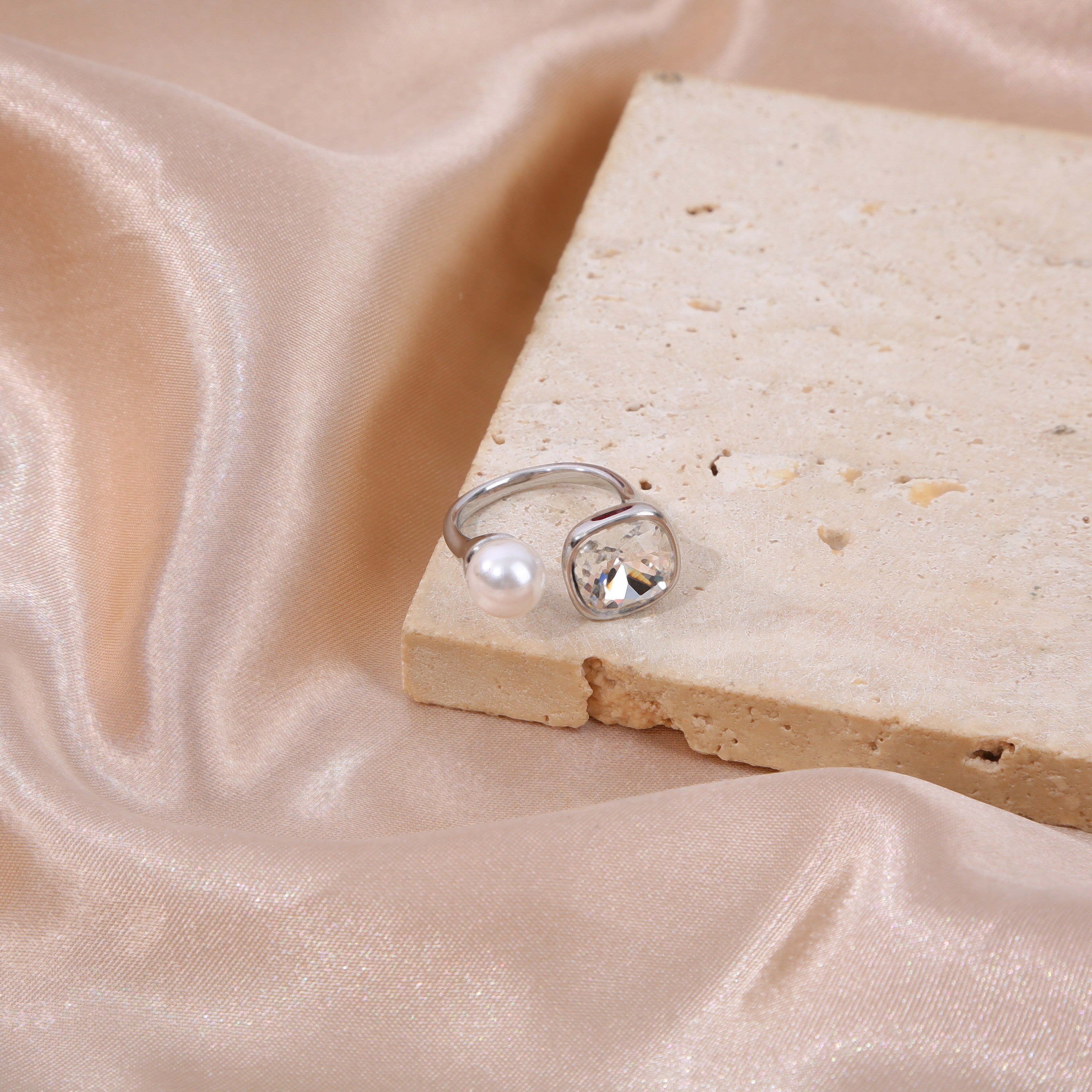 Anello in argento aperto sul davanti con strass quadrati e una perla bianca rotonda