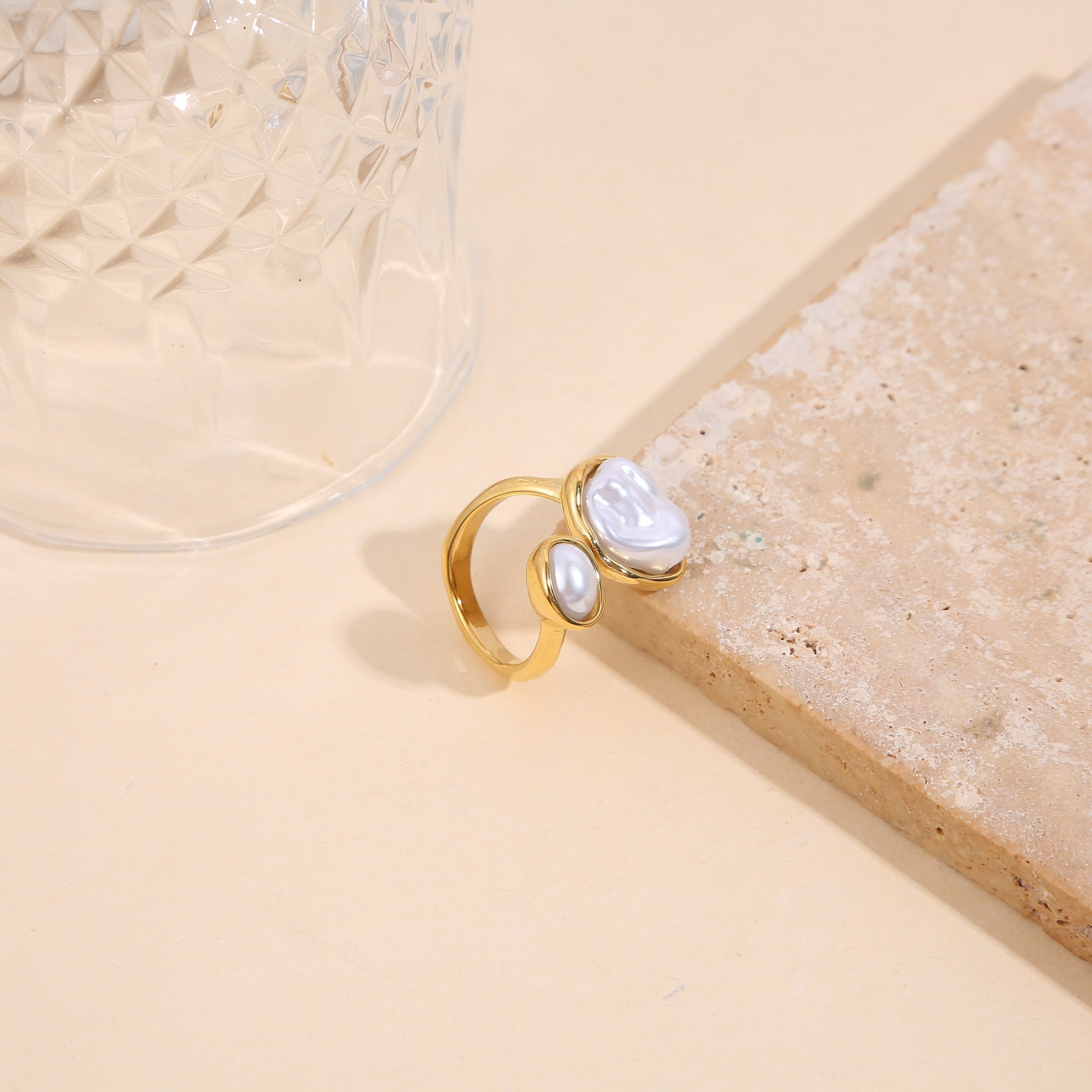 Anello color oro con apertura frontale, perla liscia e testurizzata con montatura liscia