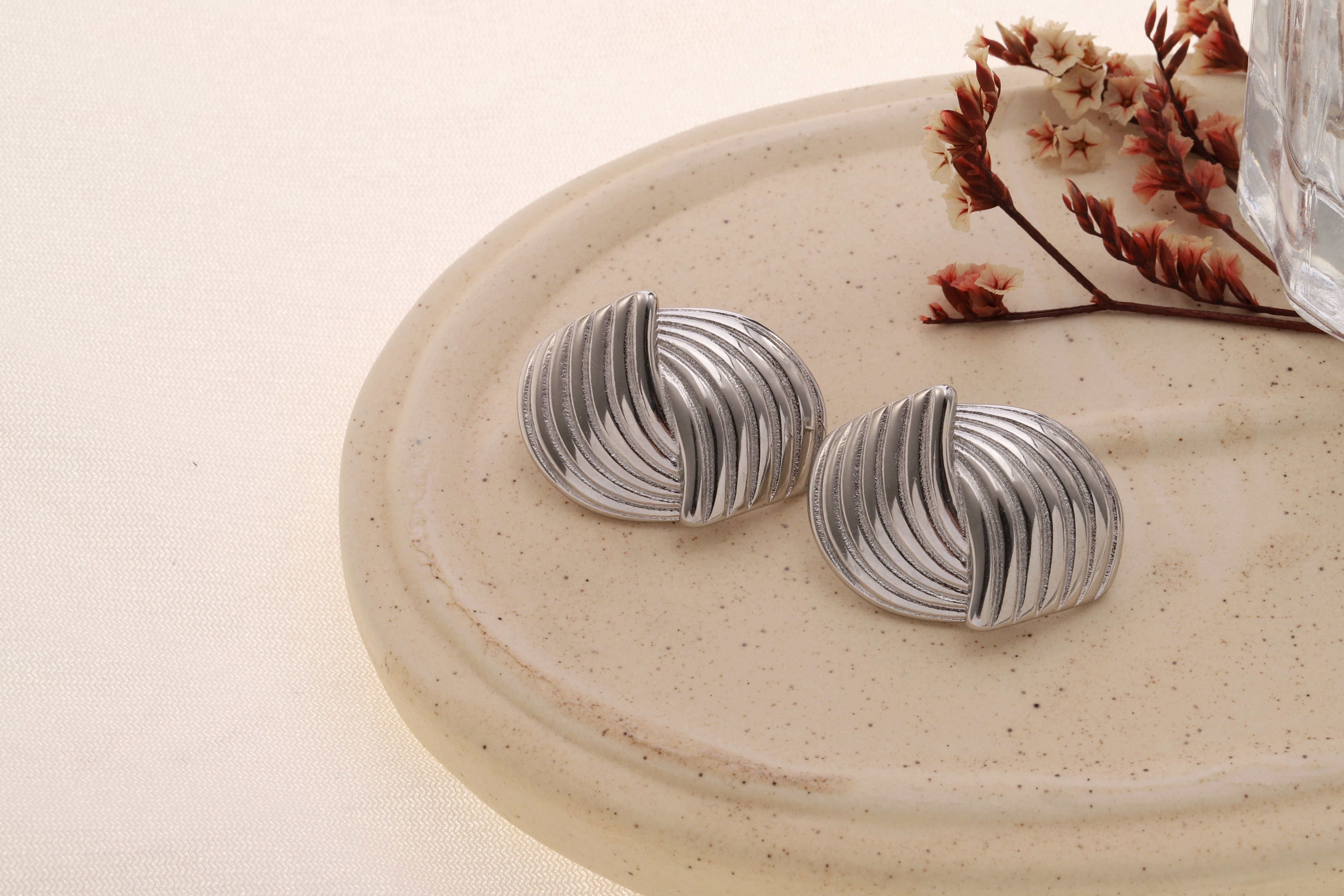 Orecchini color argento con motivo striato e ritorto