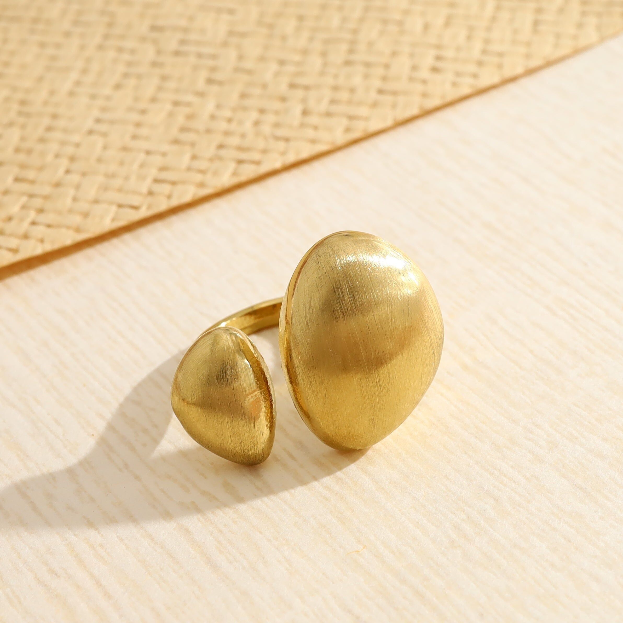 Anello color oro con apertura frontale asimmetrica bombata ed effetto spazzolato