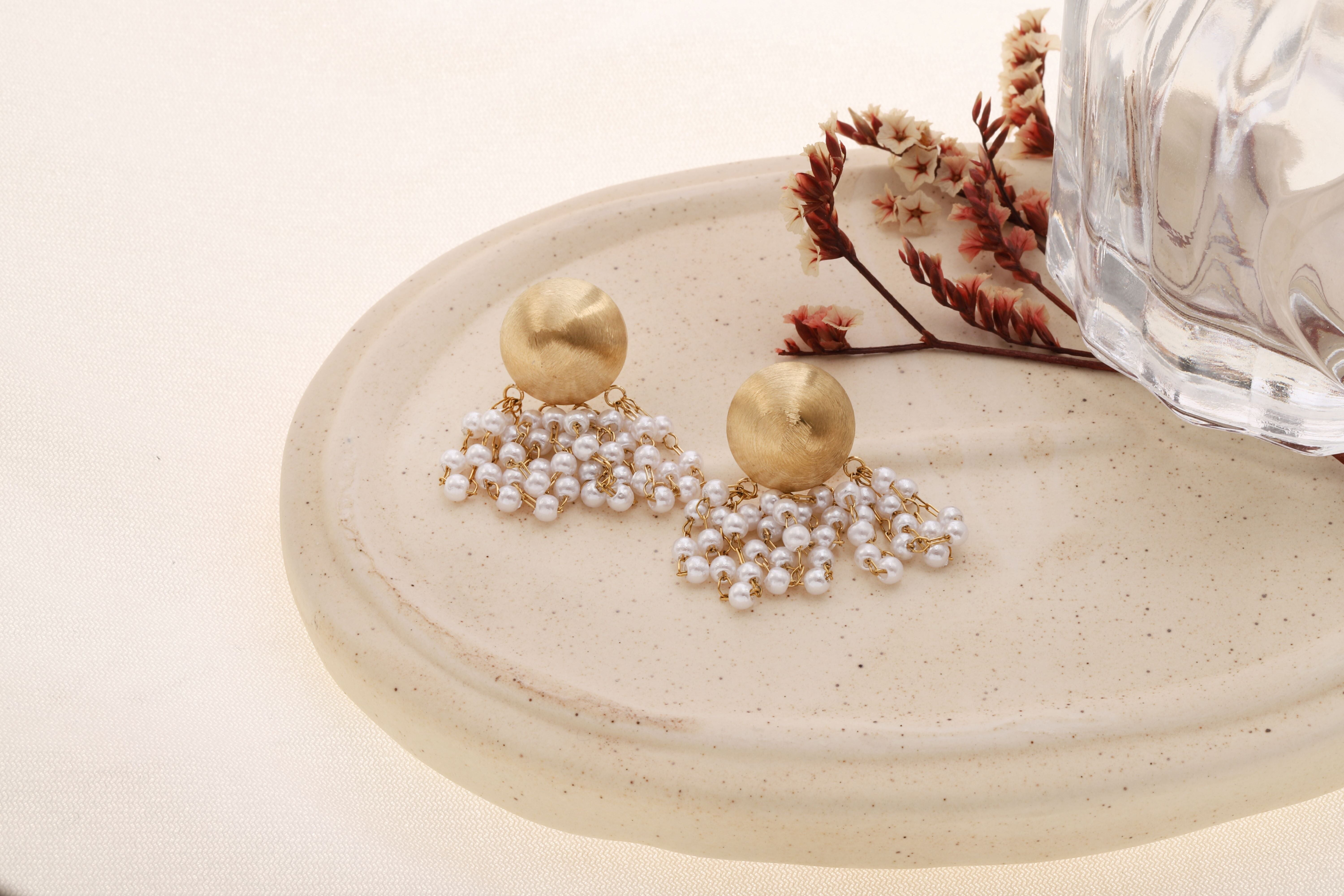 Orecchini pendenti corti color oro con pendente rotondo, bombato e spazzolato e frangia di perle