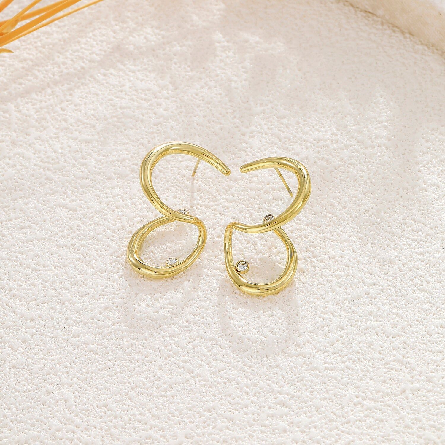Orecchini a cerchio aperti in oro a forma di goccia asimmetrica con strass centrale