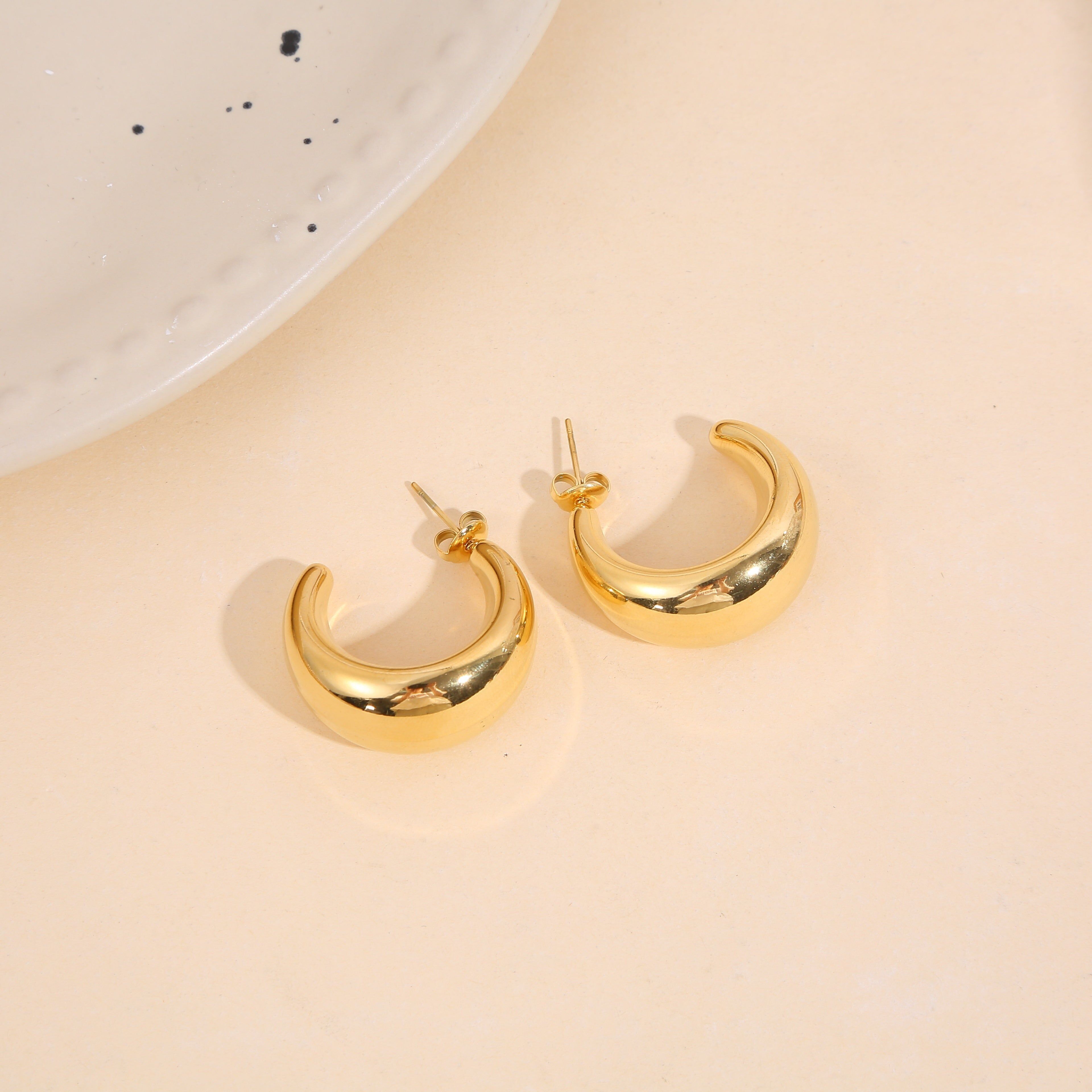 Orecchini a cerchio placcati in oro con ampia forma a mezzaluna bombata e effetto specchiato