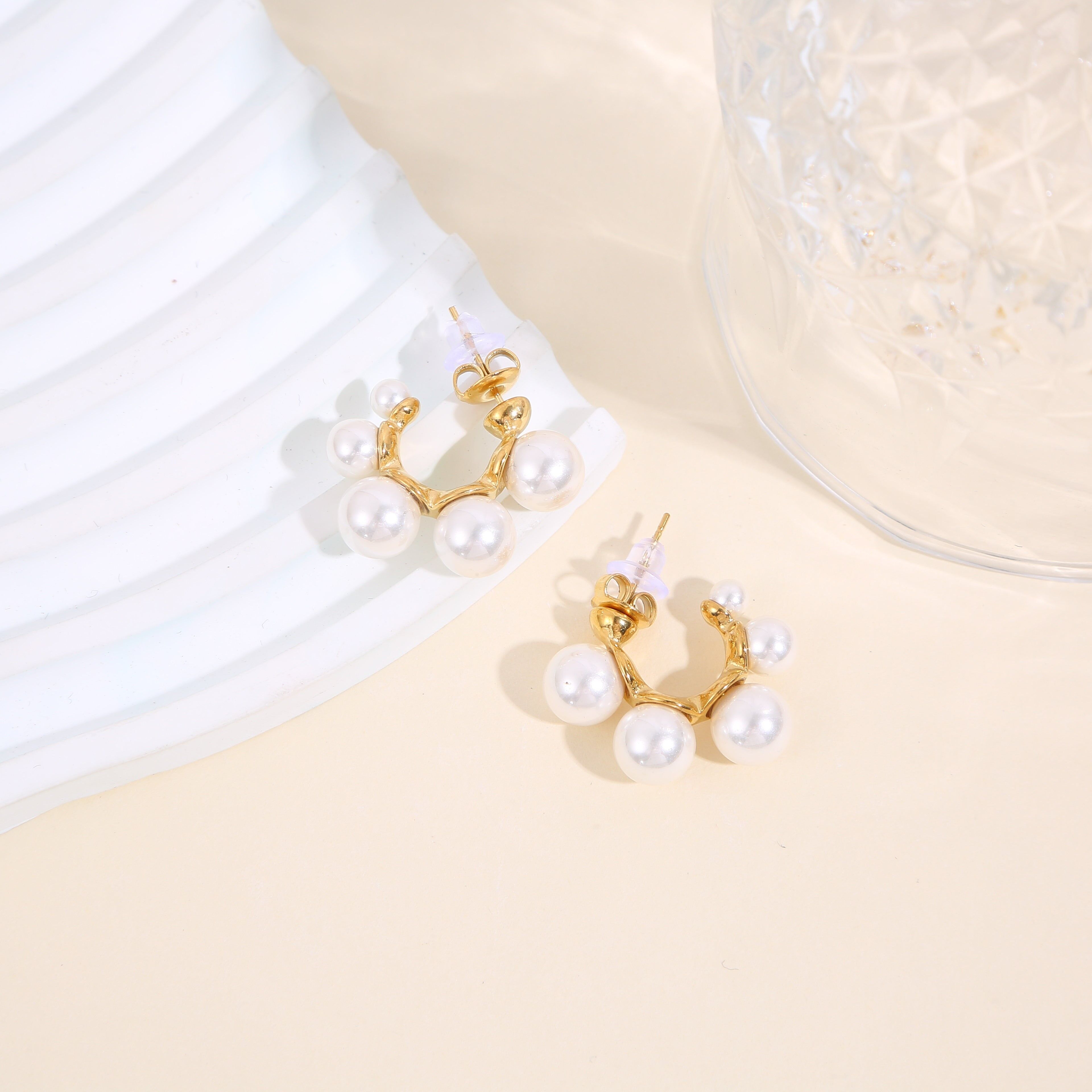 Orecchini a cerchio aperti in oro circondati da perle bianche rotonde