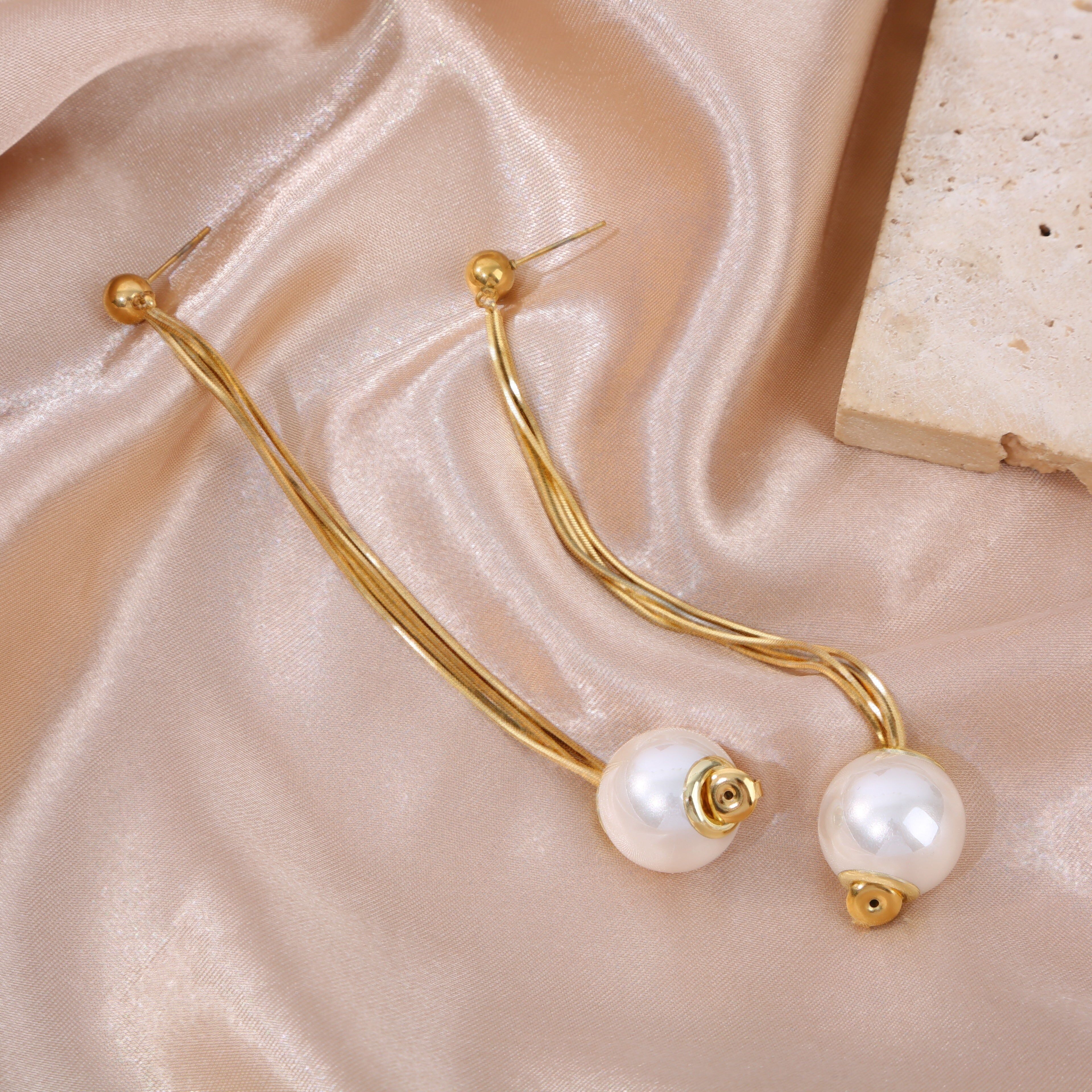 Orecchini placcati in oro con quattro catene, una chiusura all'estremità e una grande perla pendente.