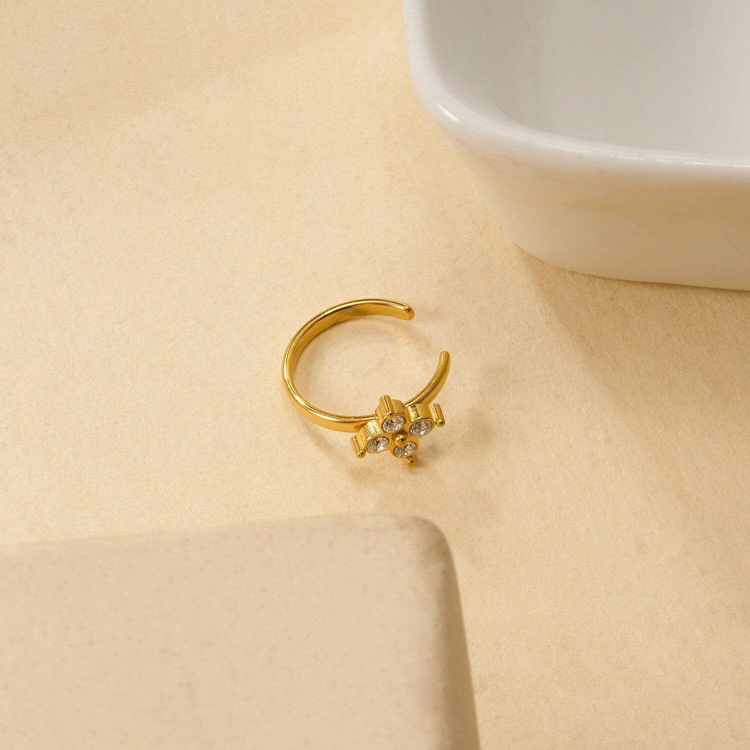 Orecchino a polsino placcato in oro con motivo a fiore a quattro petali