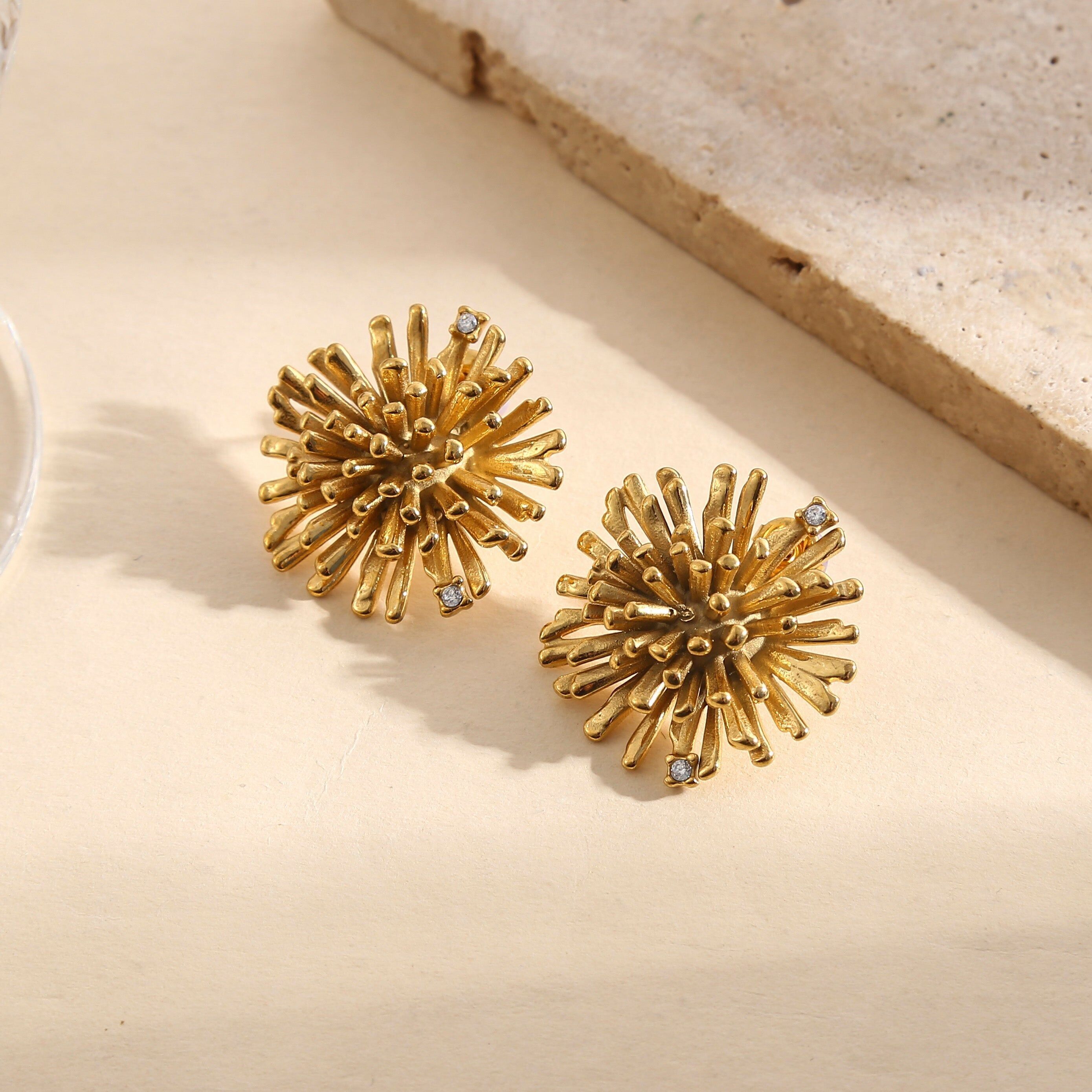 Orecchini color oro con motivo a fuochi d'artificio strutturato e strass intarsiati