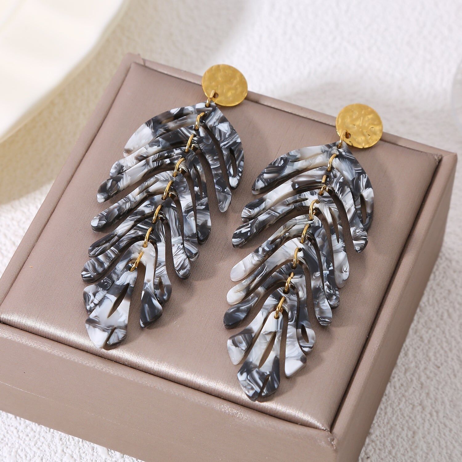 Orecchini pendenti placcati in oro con foglie incernierate bianche e nere