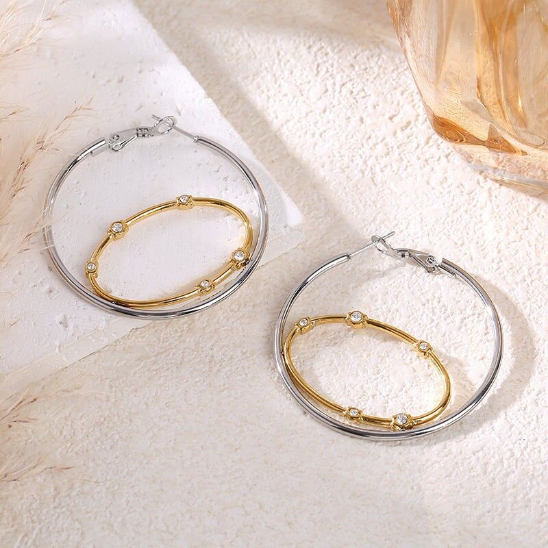 Orecchini bicolore con cerchi ovali e rotondi collegati da strass