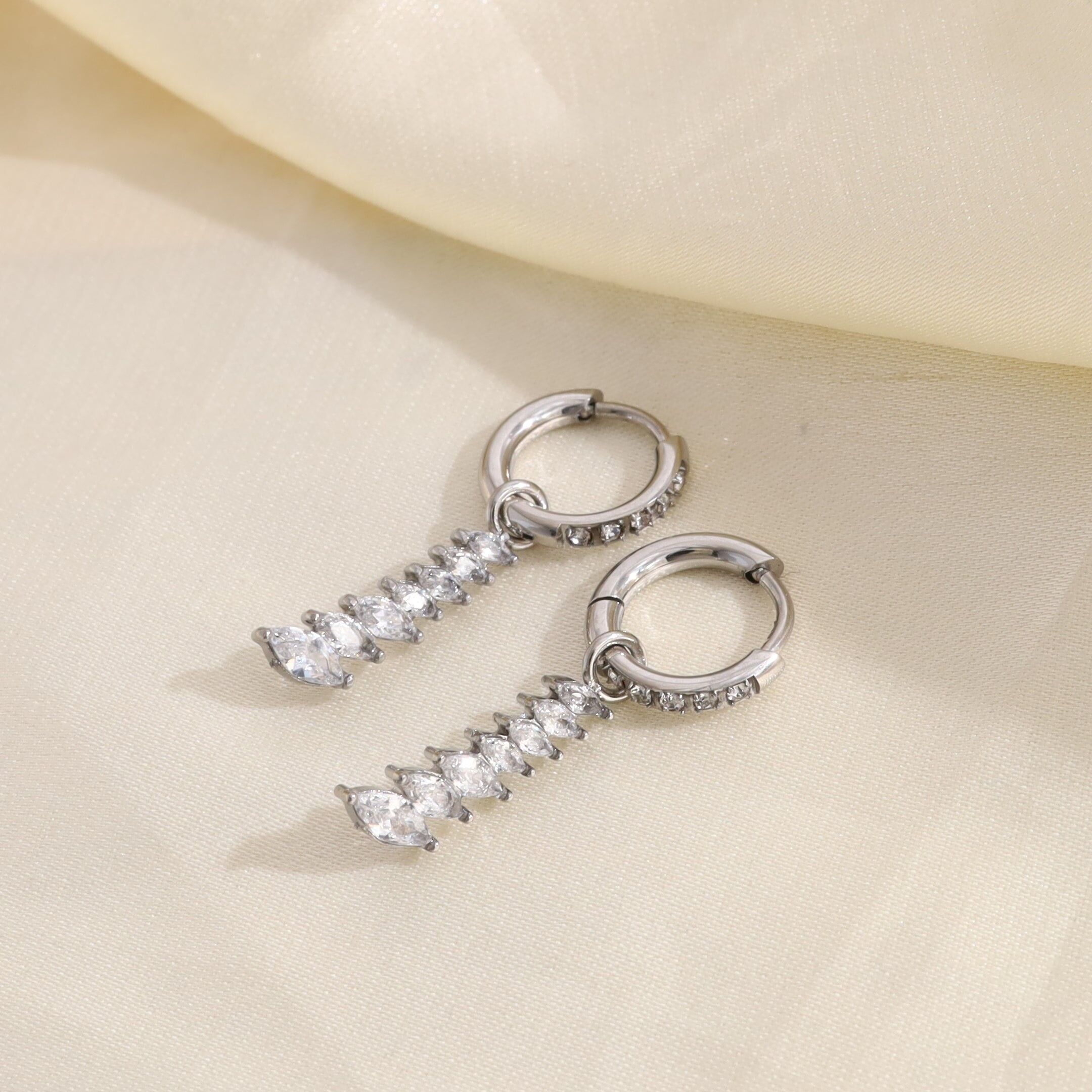 Mini orecchini a cerchio in argento con strass, caratterizzati da 7 forme di diamanti allineate