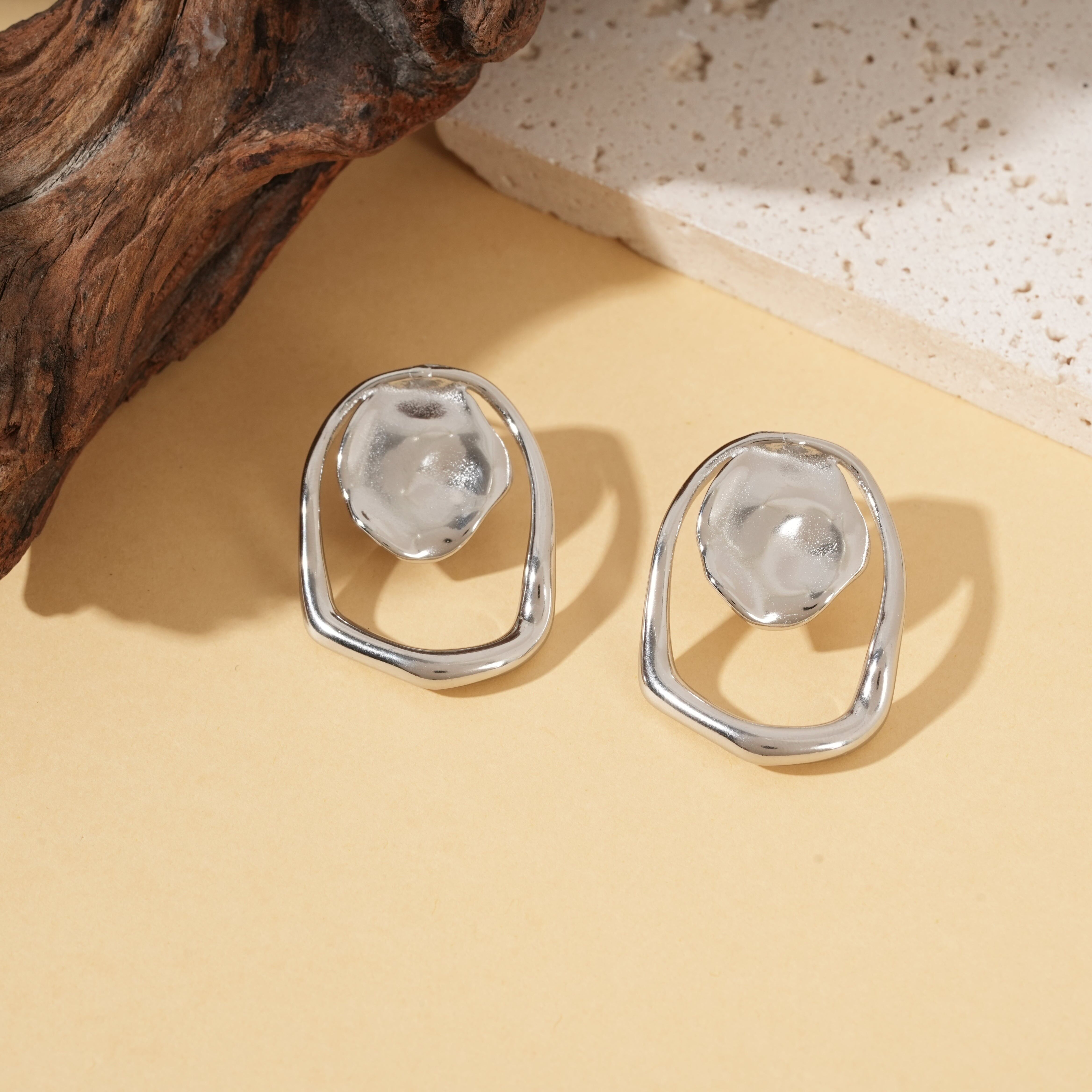 Orecchini geometrici in argento con cerchio martellato e anello irregolare con effetto specchio