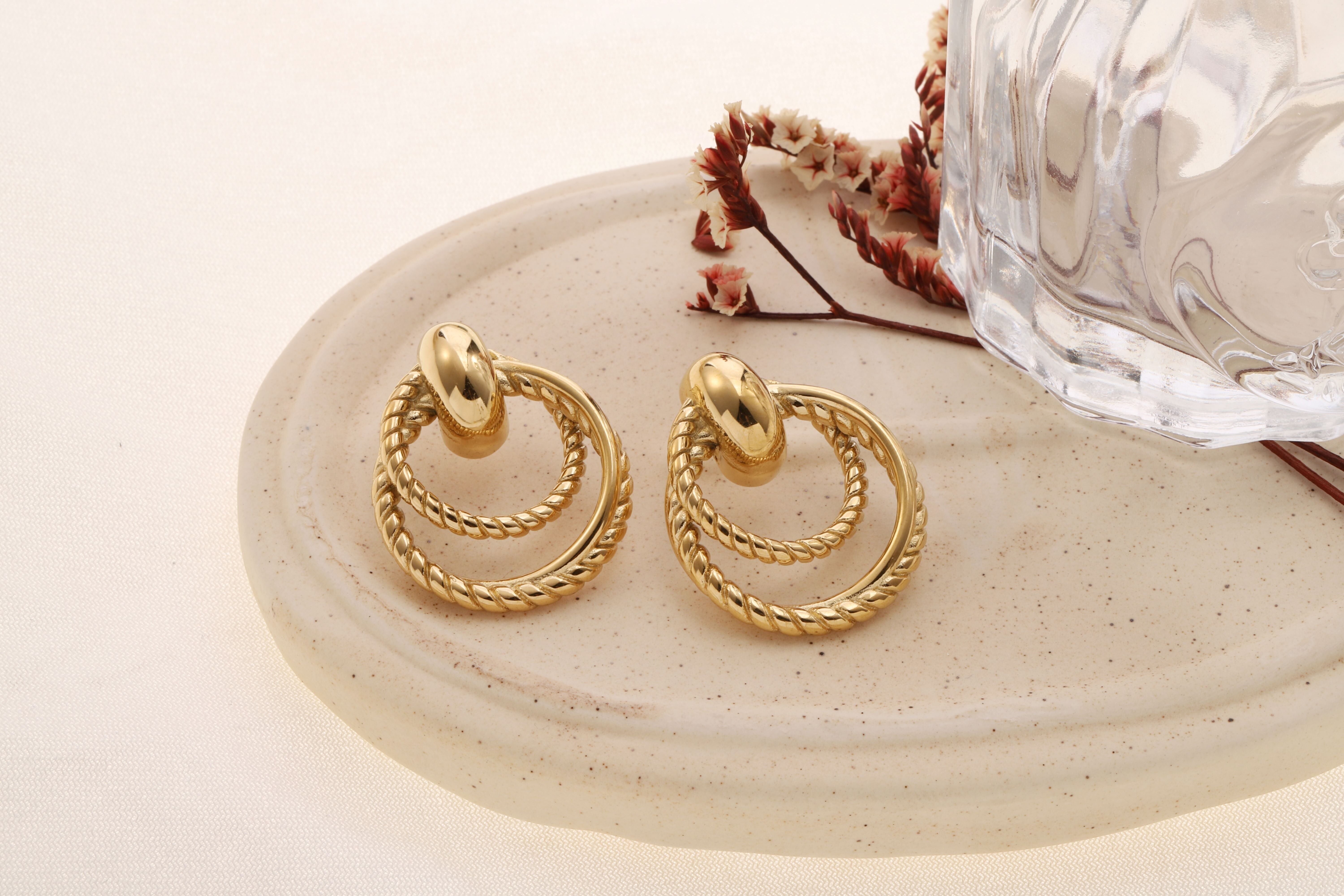 Orecchini placcati in oro con doppi cerchi intrecciati collegati da una maglia bombata lucida