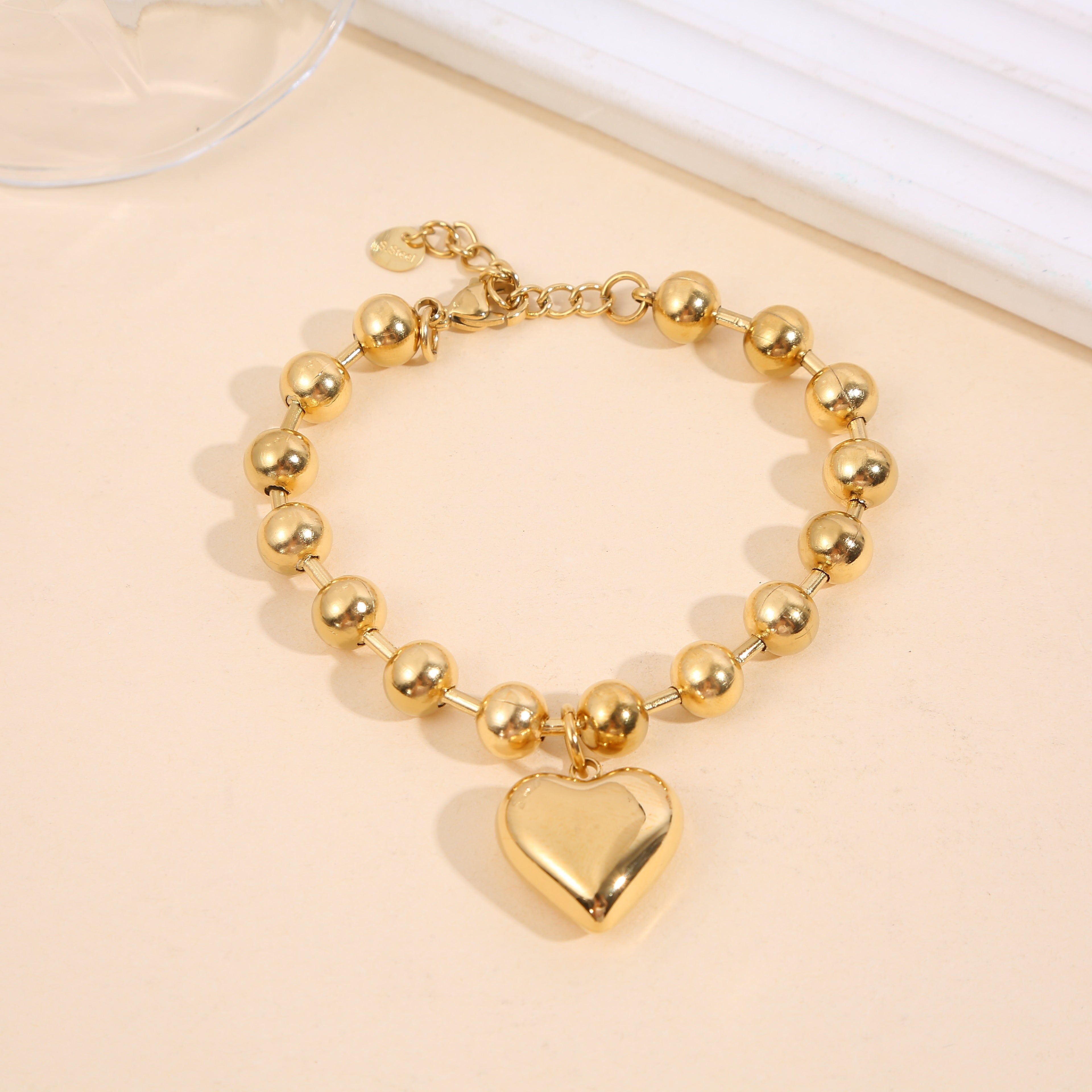 Bracciale in oro con grandi perle rotonde e un ciondolo a forma di cuore bombato