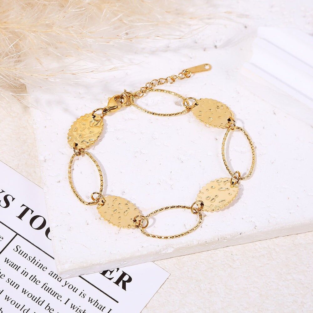 Bracciale in oro con maglie ovali testurizzate alternate a medaglioni rotondi martellati