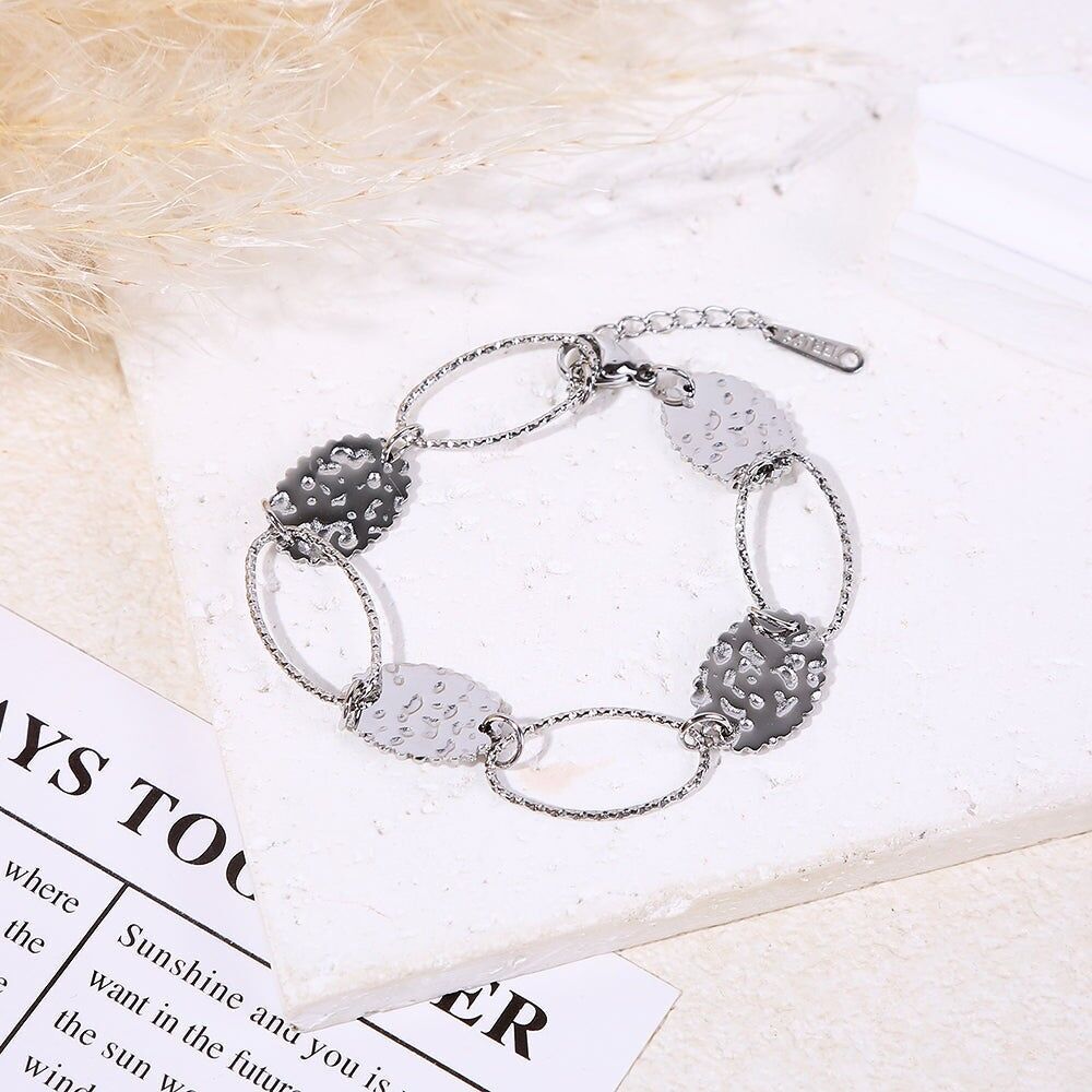 Bracciale in argento con maglie ovali testurizzate alternate a medaglioni rotondi martellati